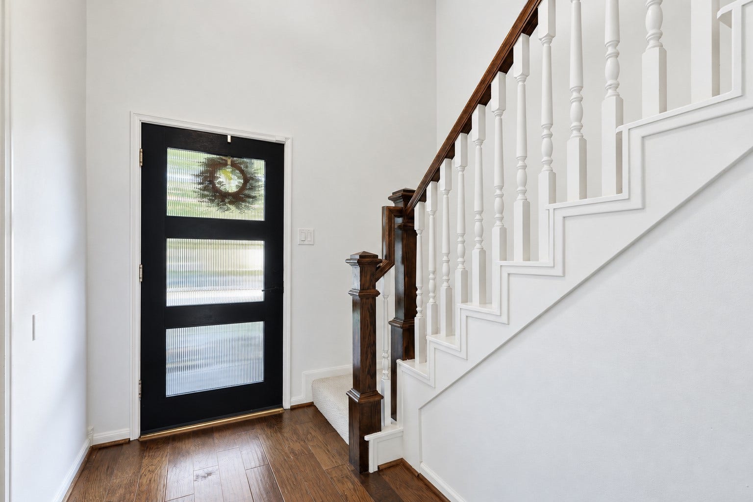 12574 Westerley Lane, Houston, TX 77077 A contemporary front door, warm wood flooring, and an open staircase create a bright, polished welcome.