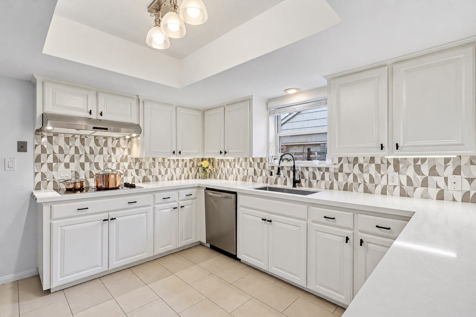 12574 Westerley Lane, Houston, TX 77077 Bright airy kitchen. this wraparound layout offers broad work surfaces and plentiful cabinetry, with a patterned backsplash adding visual interest.