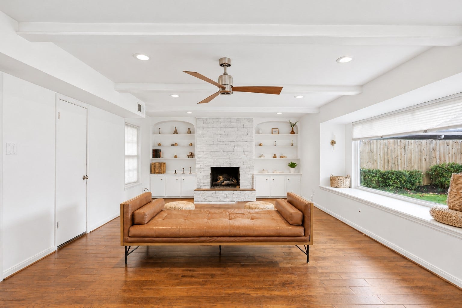 12574 Westerley Lane, Houston, TX 77077 Natural light washes across warm wood flooring beneath a beamed ceiling, with a broad garden view adding a refreshing connection to the outdoors.