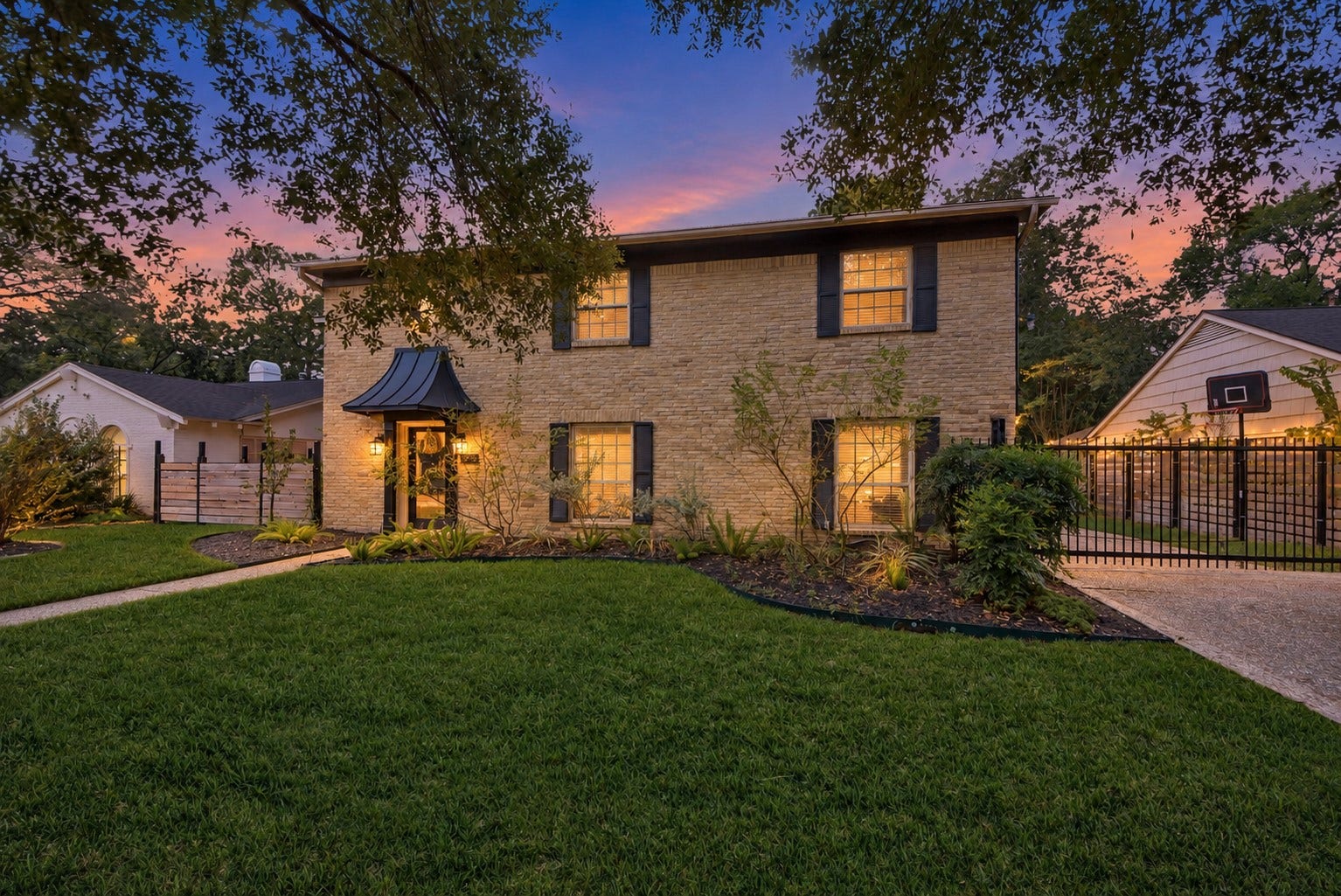 12574 Westerley Lane, Houston, TX 77077 Framed by mature trees, the brick exterior and glowing entry make a beautiful first impression beneath a soft twilight sky.