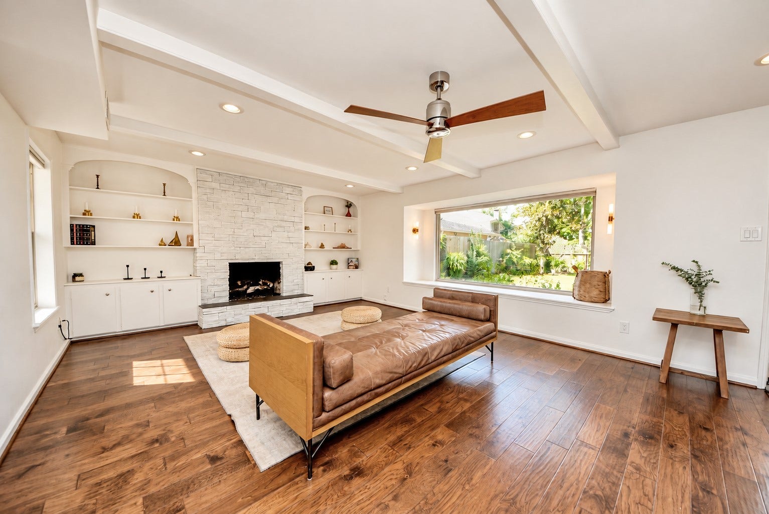 12574 Westerley Lane, Houston, TX 77077 Balanced daylight interior. A broad picture window, white ceiling beams, and a fireplace framed by built-ins make this living room both sophisticated and inviting.