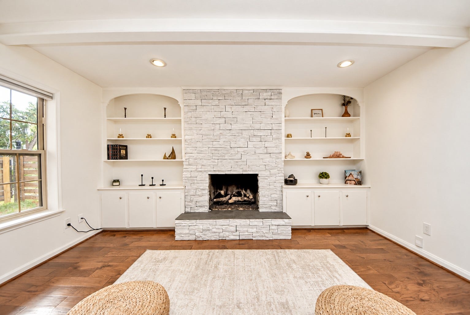 12574 Westerley Lane, Houston, TX 77077 Warm modern organic interior: painted brick fireplace and arched built-ins lend timeless character to this living space, balanced by warm wood floors and soft natural light.