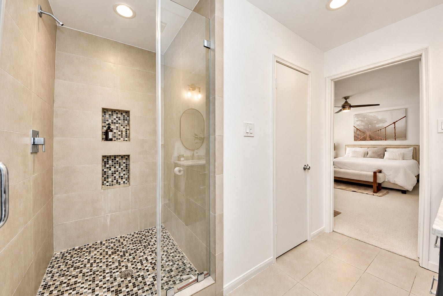 12574 Westerley Lane, Houston, TX 77077 Organic, balanced, contemporary and airy:The glass-enclosed shower, pebble-style floor, and soft neutral finishes create a serene bathroom setting beside the bedroom.