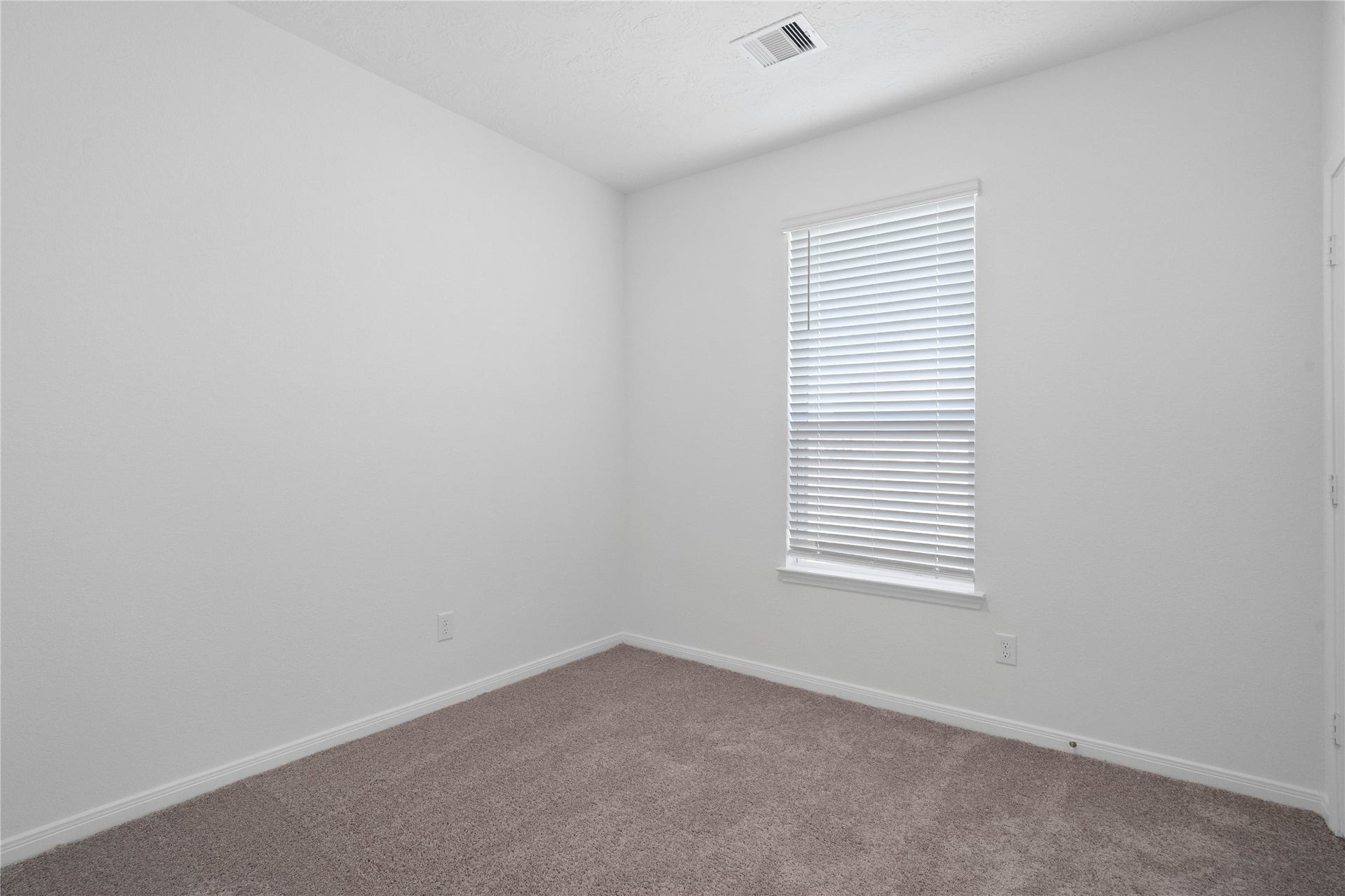 5619 Blackbird Lane, Hitchcock, TX 77563 This secondary bedroom offers comfort and style with plush carpeting, neutral paint tones, recessed lighting, a large window with blinds, and a generously sized closet.