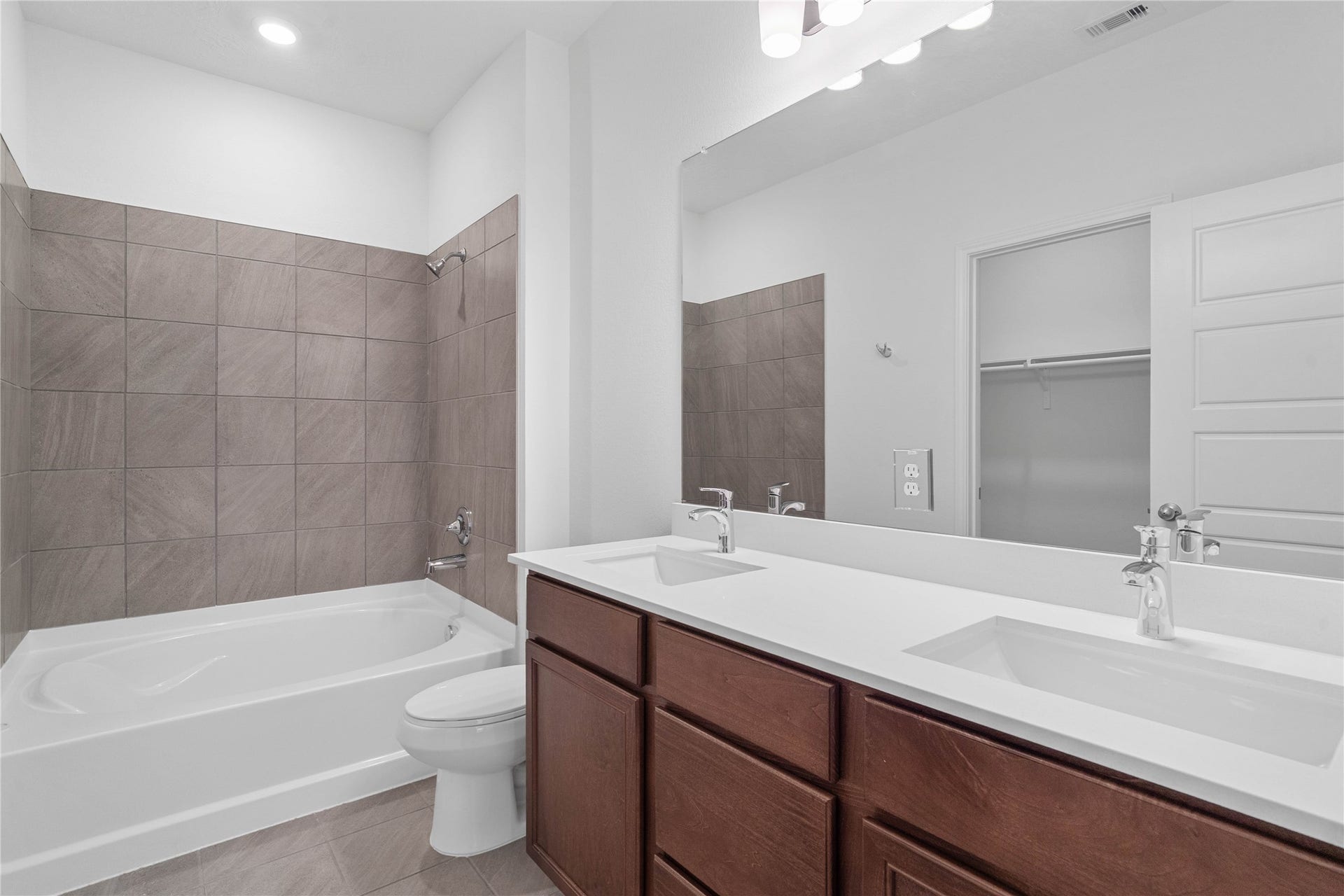 5619 Blackbird Lane, Hitchcock, TX 77563 This beautifully updated primary bathroom is move-in ready! It showcases stained cabinetry paired with light countertops, dual vanity sinks, a large mirror, spacious walk-in closet with built-in shelving, high ceilings, custom paint, and stylish modern finishes throughout.
