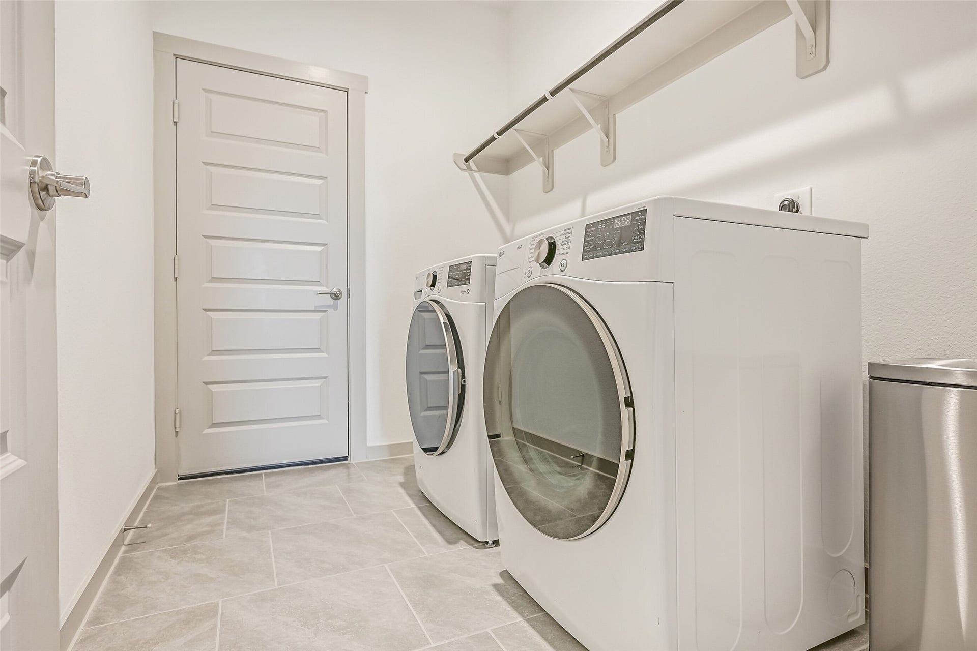 6204 Red Oak Court, League City, TX 77573 The spacious interior utility room accommodates full-size side-by-side laundry appliances and features easy-care tile flooring plus a long shelf and hanging rod for added storage and functionality.