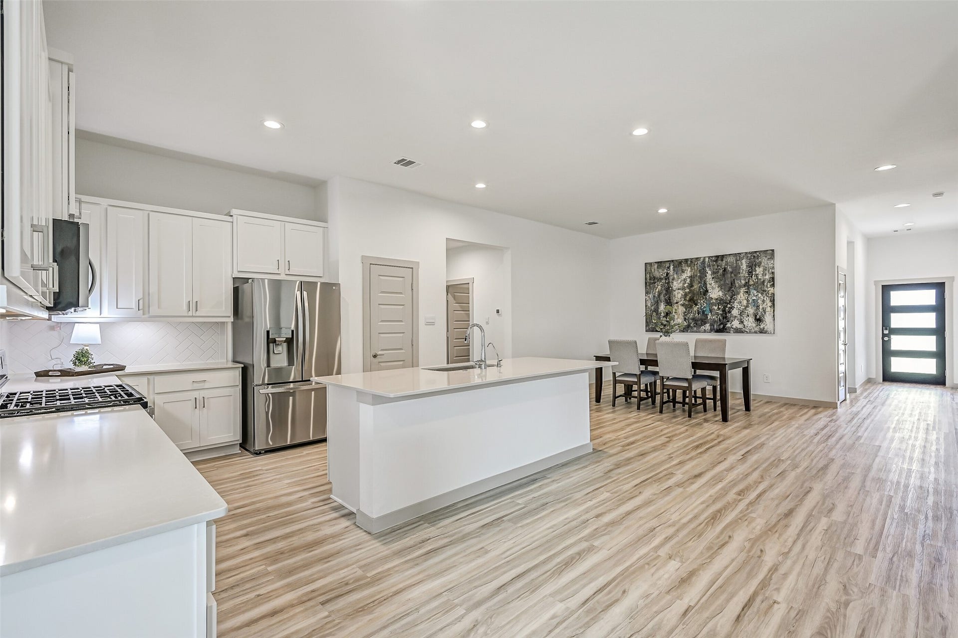 6204 Red Oak Court, League City, TX 77573 The heart of the home is an impressive open-concept kitchen & dining space with an oversized island, abundant cabinetry, stainless appliances and continuous wood-look flooring that creates a seamless flow throughout the main living areas.