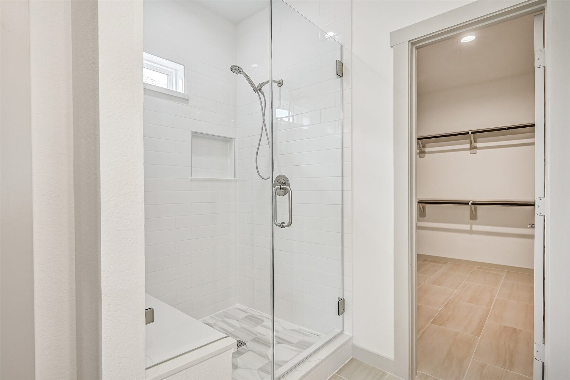 6204 Red Oak Court, League City, TX 77573 An oversized frameless glass shower showcases crisp tile surrounds, a built-in niche, handheld showerhead and natural light, creating a clean contemporary focal point in the primary bath.