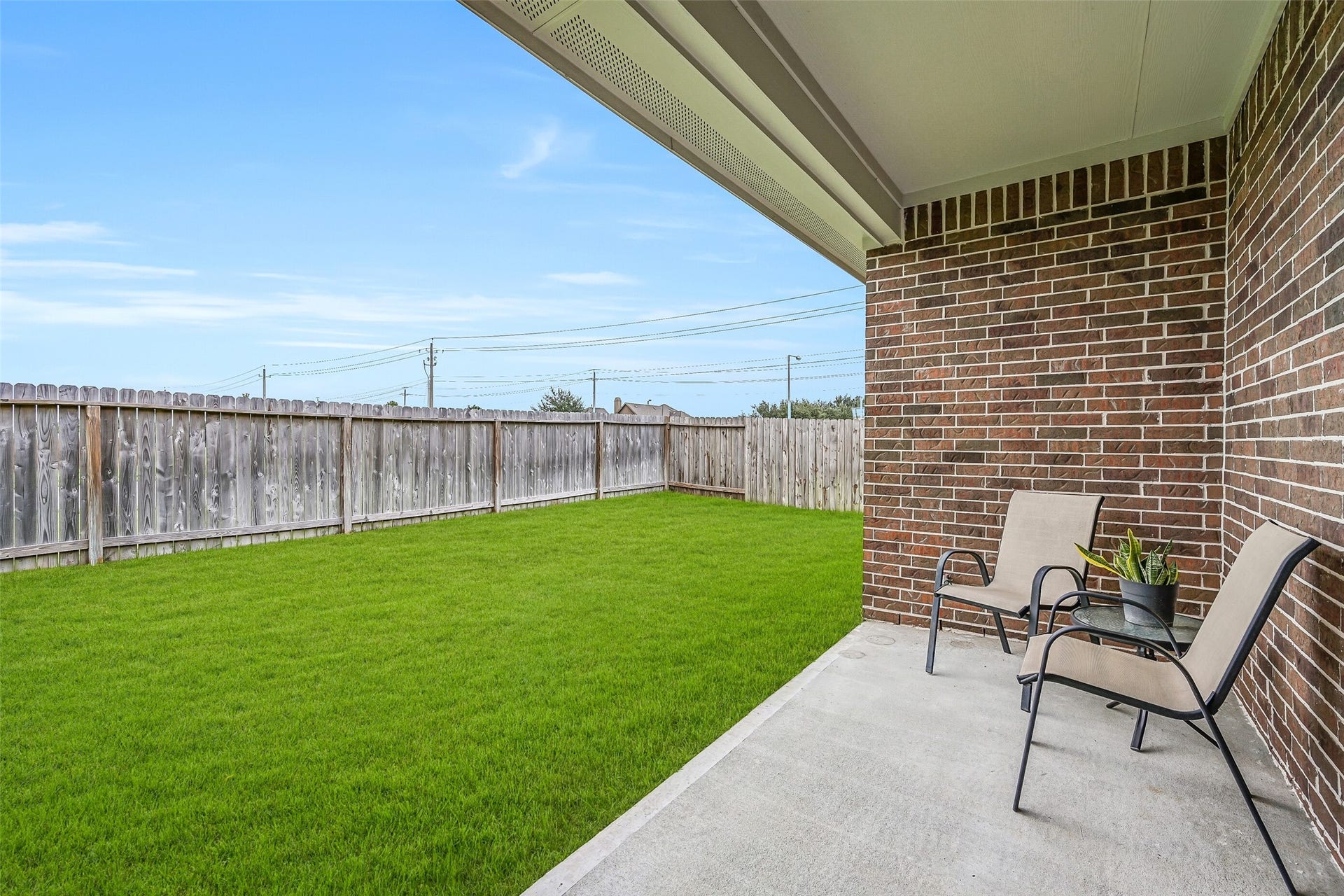 6204 Red Oak Court, League City, TX 77573 Step outside to the covered rear patio overlooking the spacious fenced backyard, offering a shaded spot for outdoor dining, morning coffee or simply relaxing while enjoying the green space beyond.