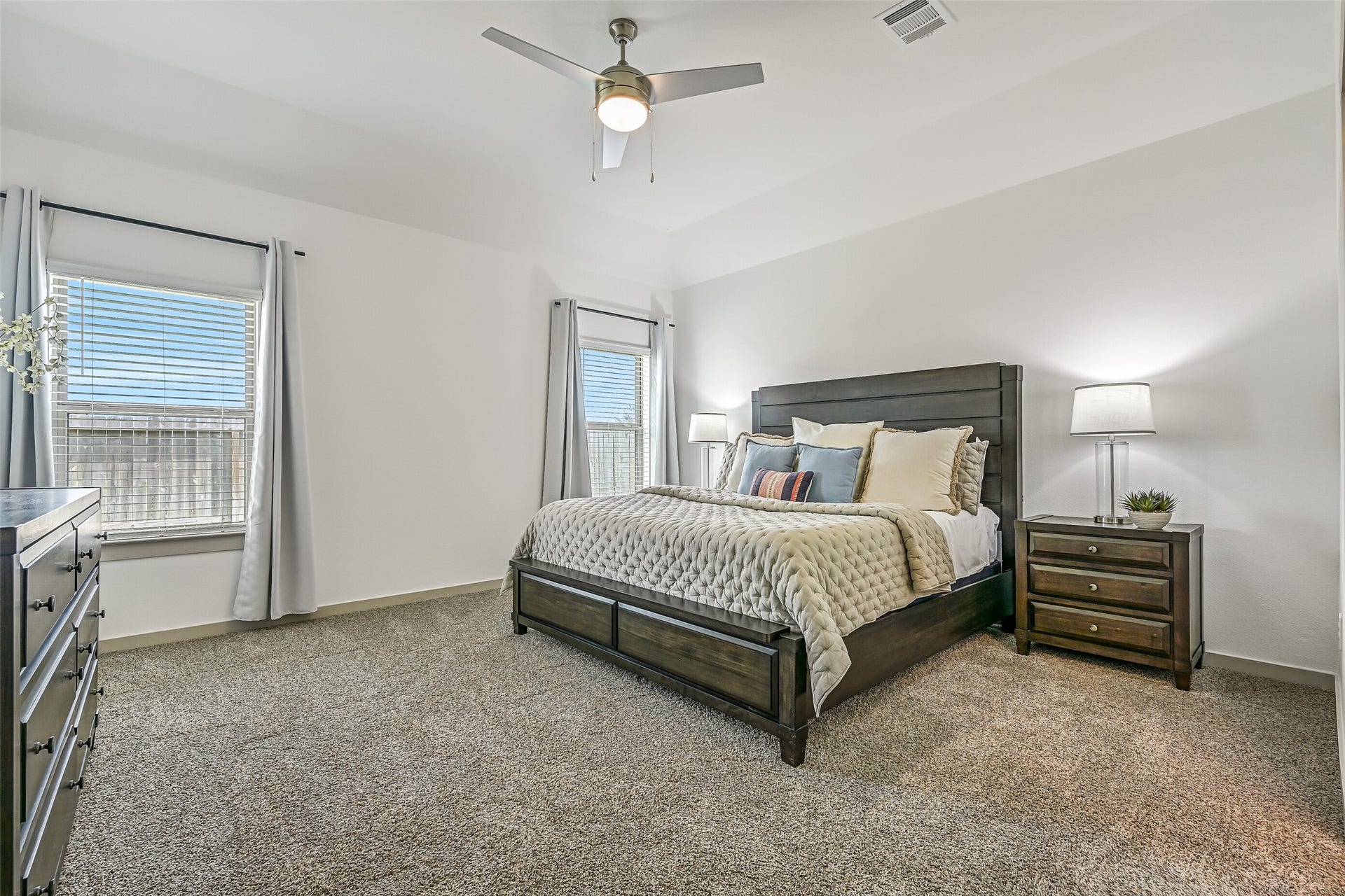 6204 Red Oak Court, League City, TX 77573 The spacious and secluded primary retreat offers a gambrel ceiling with ceiling fan, plush neutral carpet and multiple windows providing abundant natural light, with plenty of room for a full complement of bedroom furnishings.