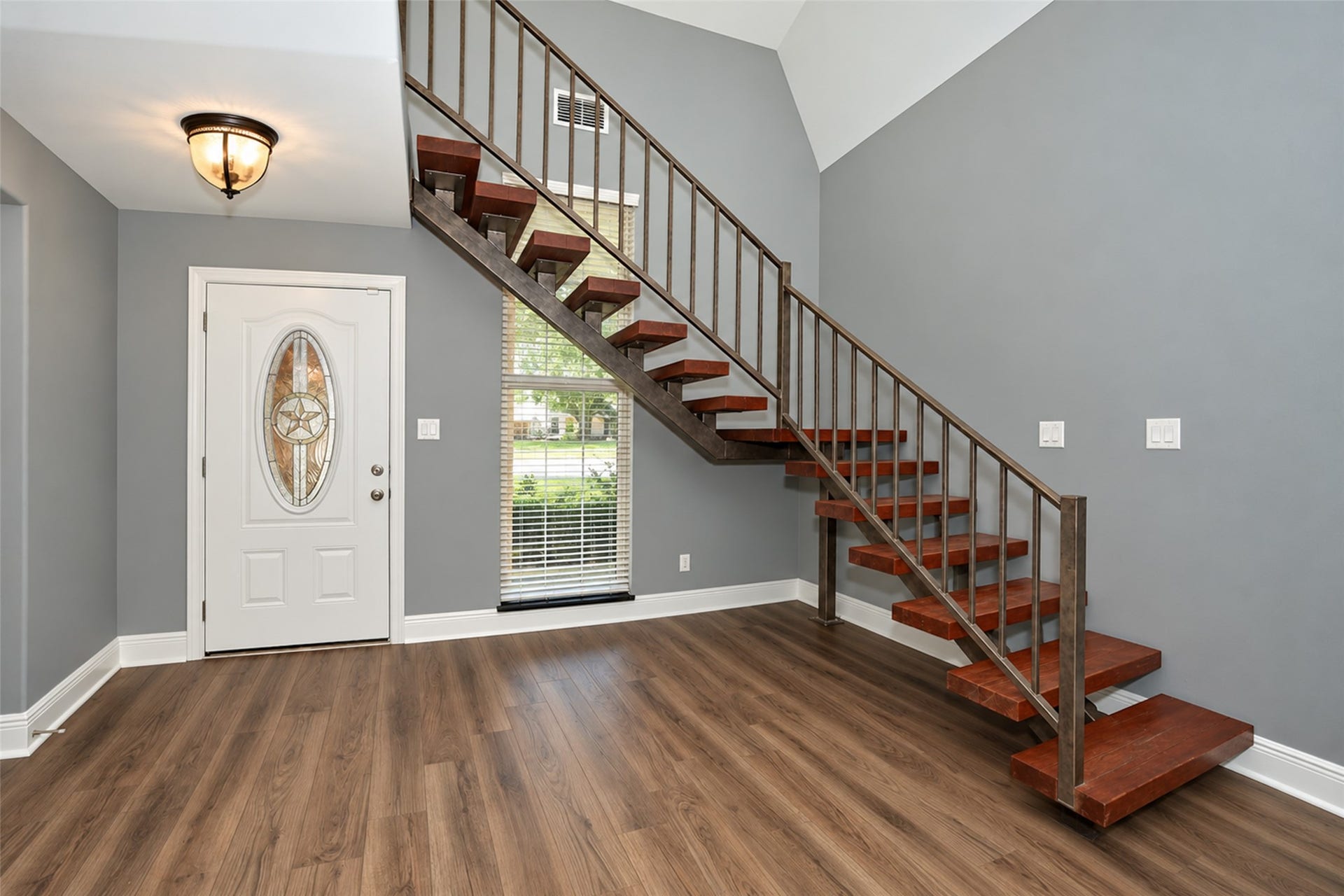 5342 Pine Cliff Drive, Houston, TX 77084 Custom wooden stairs and a striking metal stair rail crafted from reclaimed materials salvaged from a historic downtown Houston building, adding unique character and a one-of-a-kind touch to the home.