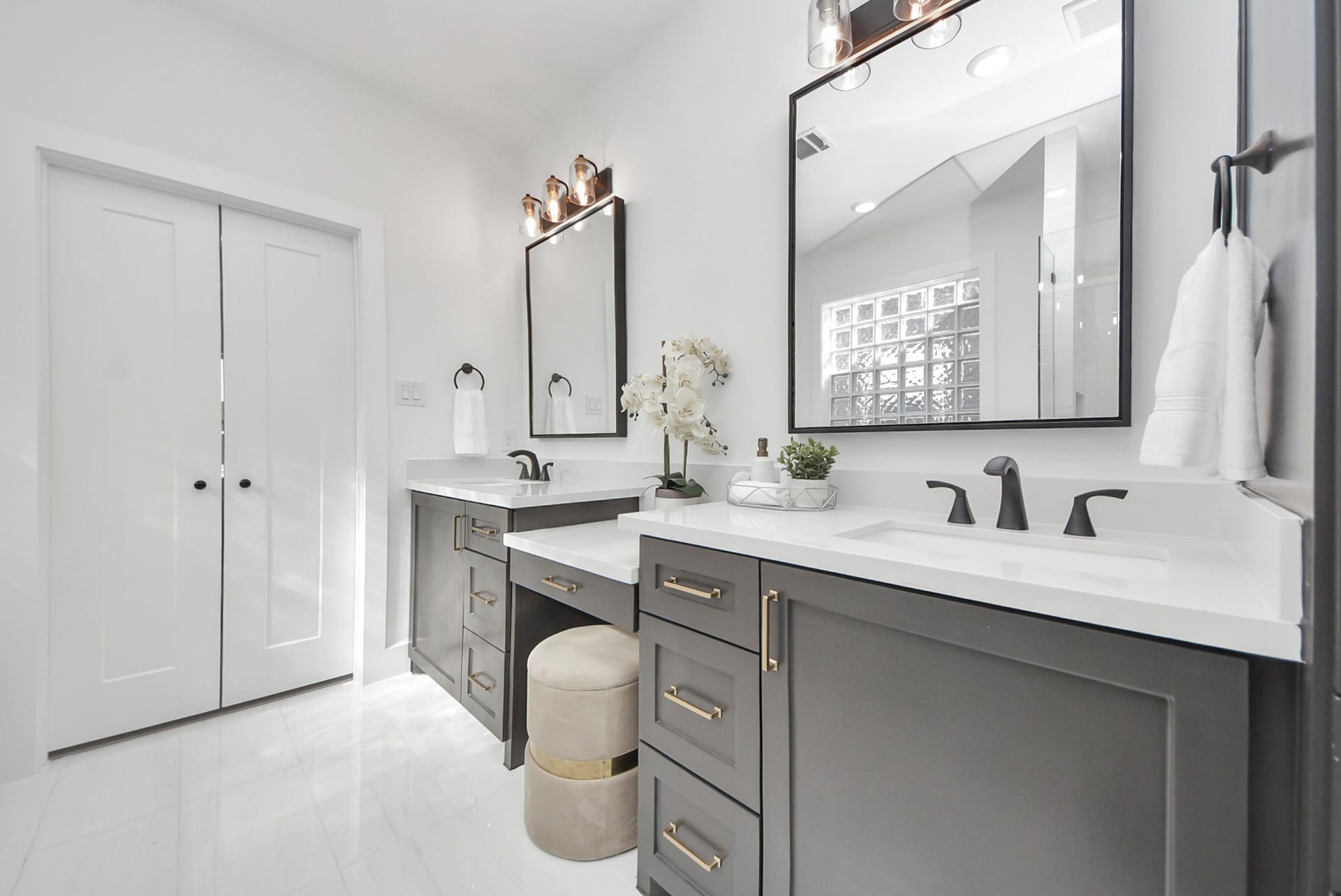 923 Fisher Street, #E, Houston, TX 77018 This bathroom features a sleek double vanity with black fixtures and ample storage. Neutral tones, large mirrors, and contemporary lighting contribute to a bright, elegant environment.