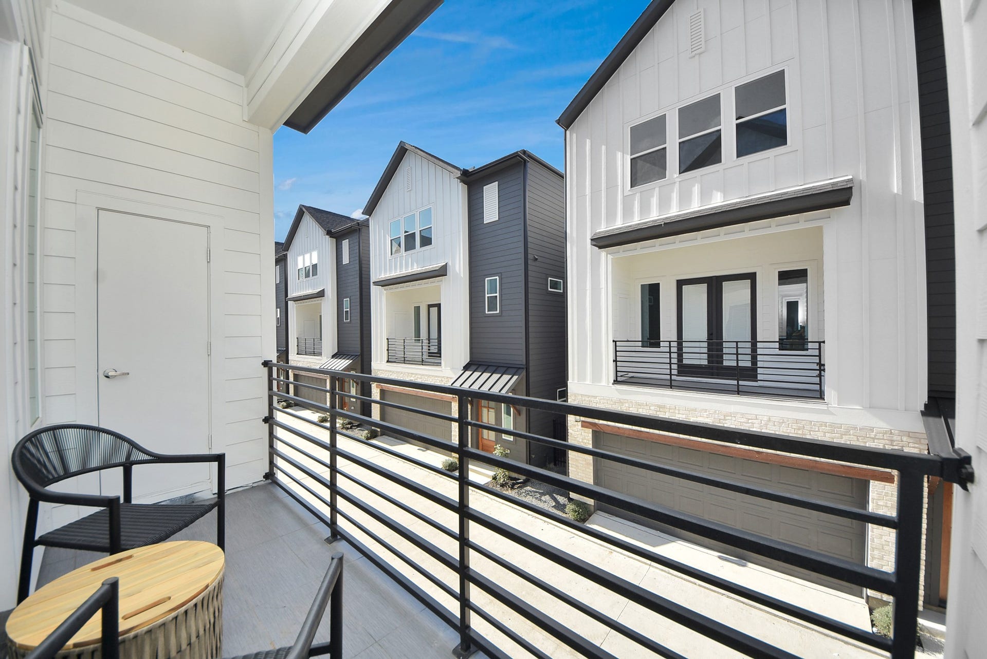 923 Fisher Street, #E, Houston, TX 77018 This cozy balcony offers a serene outdoor space with sleek railings, two chairs, and a small tableideal for enjoying morning coffee or evening relaxation while taking in the neighborhood views.