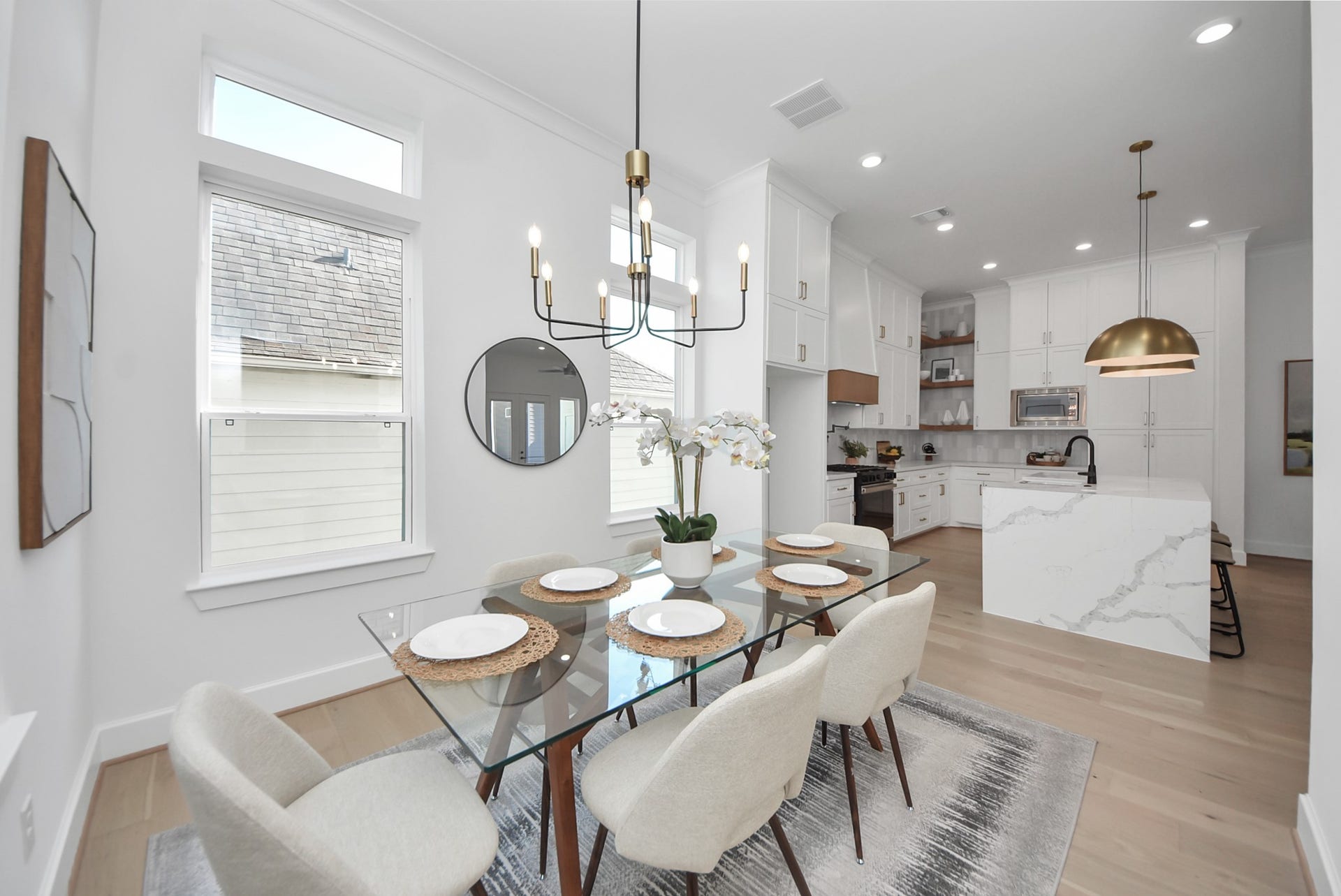 923 Fisher Street, #E, Houston, TX 77018 This spacious bedroom features a modern ceiling fan, recessed lighting, and a neutral color scheme. It includes a cozy sitting area, a dresser, and access to a walk-in closet and en-suite bathroom.