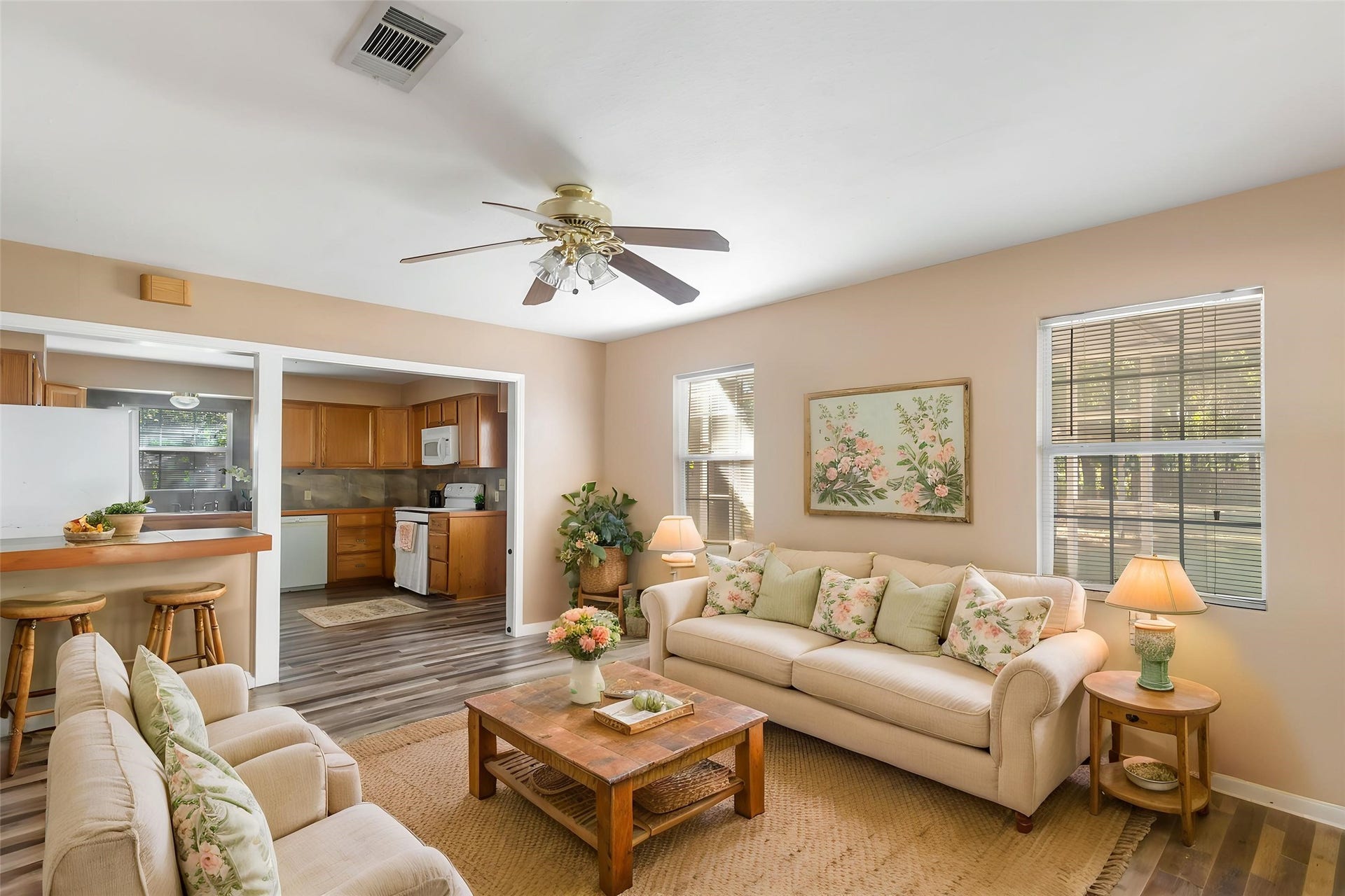 23304 E Community Drive, New Caney, TX 77357 Comfortable living area with natural light, wood-look flooring and a ceiling fan. A great opportunity to personalize a home with room to make it your own. (This photo is virtually staged.)