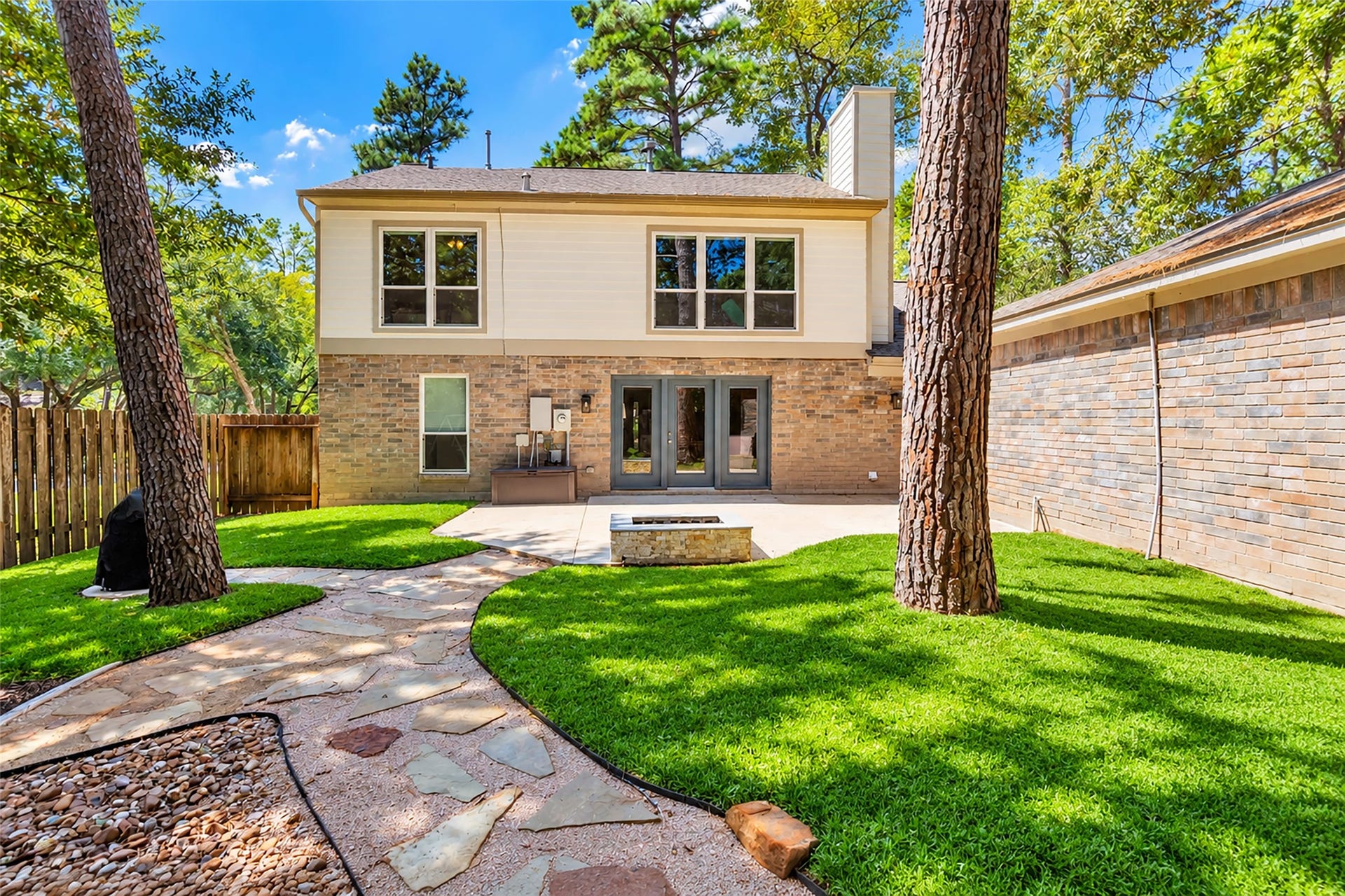 2 Tall Sky Place, The Woodlands, TX 77381 Large backyard with shade, firepit, and stone path walkway