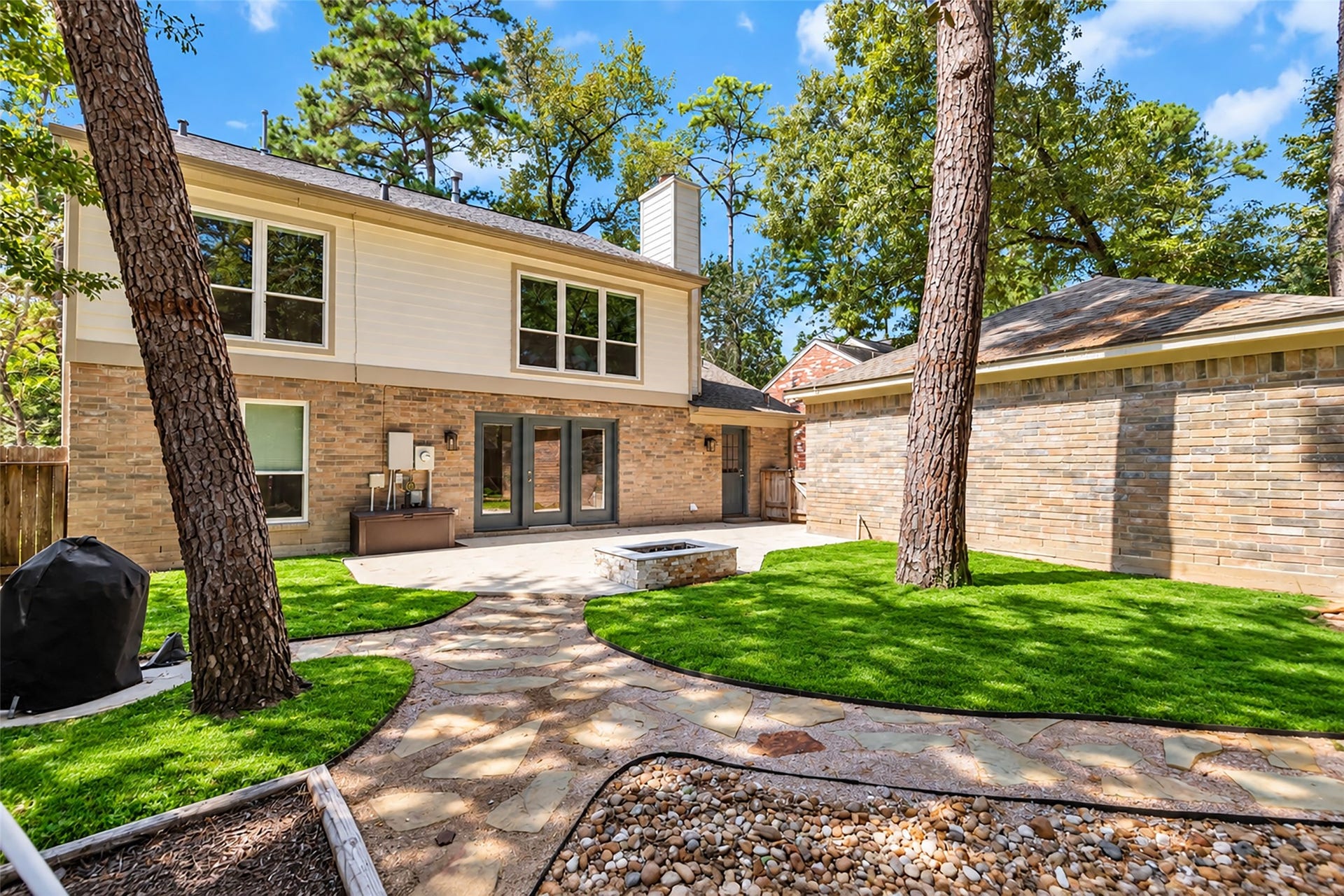 2 Tall Sky Place, The Woodlands, TX 77381 Large backyard with shade, firepit, and stone path walkway