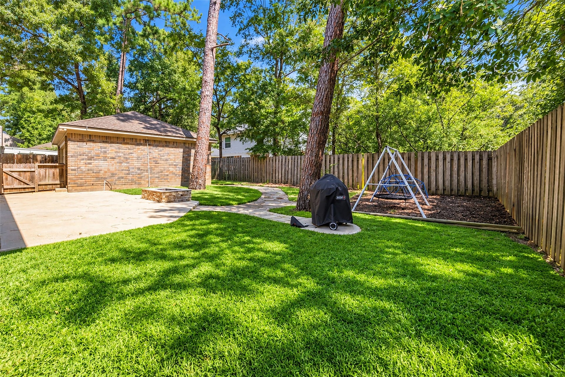 2 Tall Sky Place, The Woodlands, TX 77381 Large backyard with shade, firepit, and stone path walkway