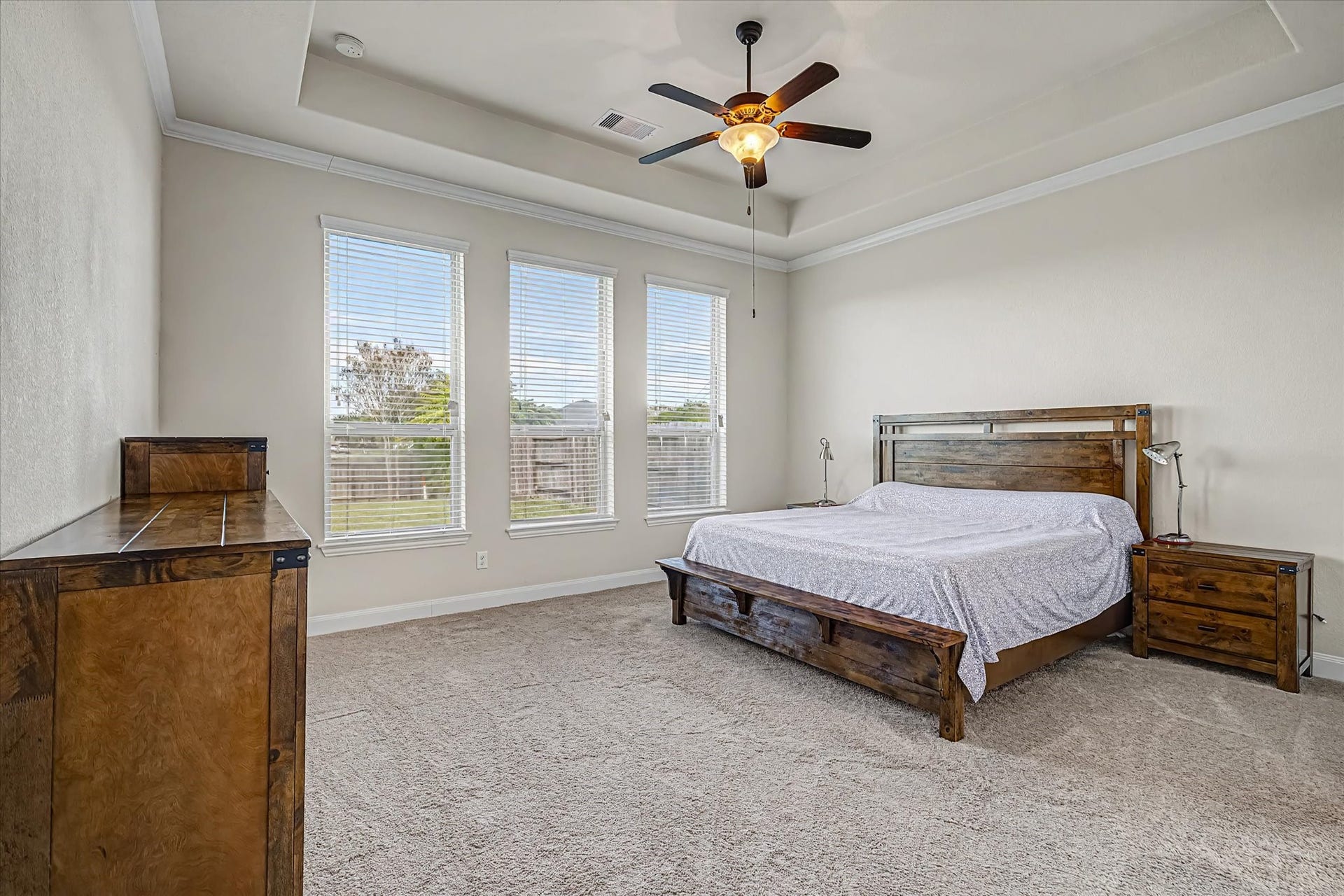 20302 Bandera Lake Lane, Richmond, TX 77407 Spacious primary bedroom with large windows offering abundant natural light, featuring a ceiling fan.