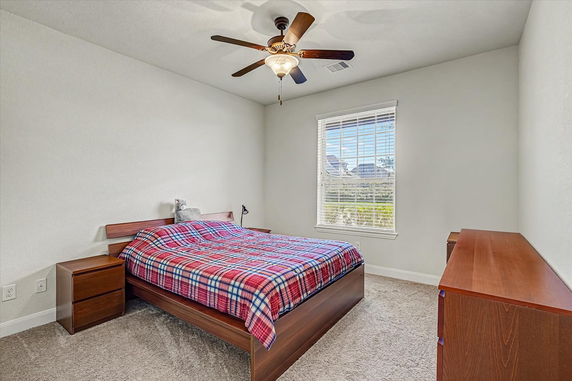 20302 Bandera Lake Lane, Richmond, TX 77407 Cozy secondary bedroom downstairs with natural light complemented by a ceiling fan for added comfort.