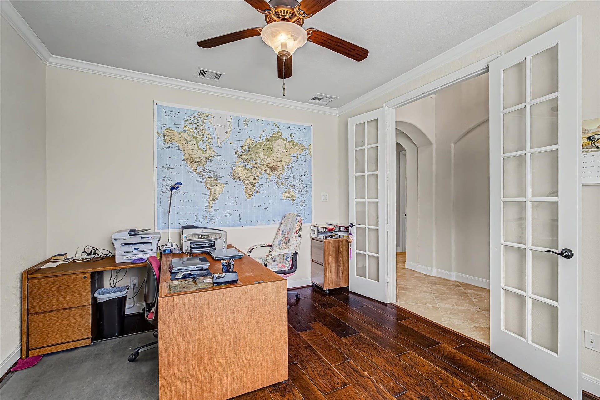 20302 Bandera Lake Lane, Richmond, TX 77407 Bright home office with elegant French doors, rich hardwood floors, and a ceiling fan for comfort.