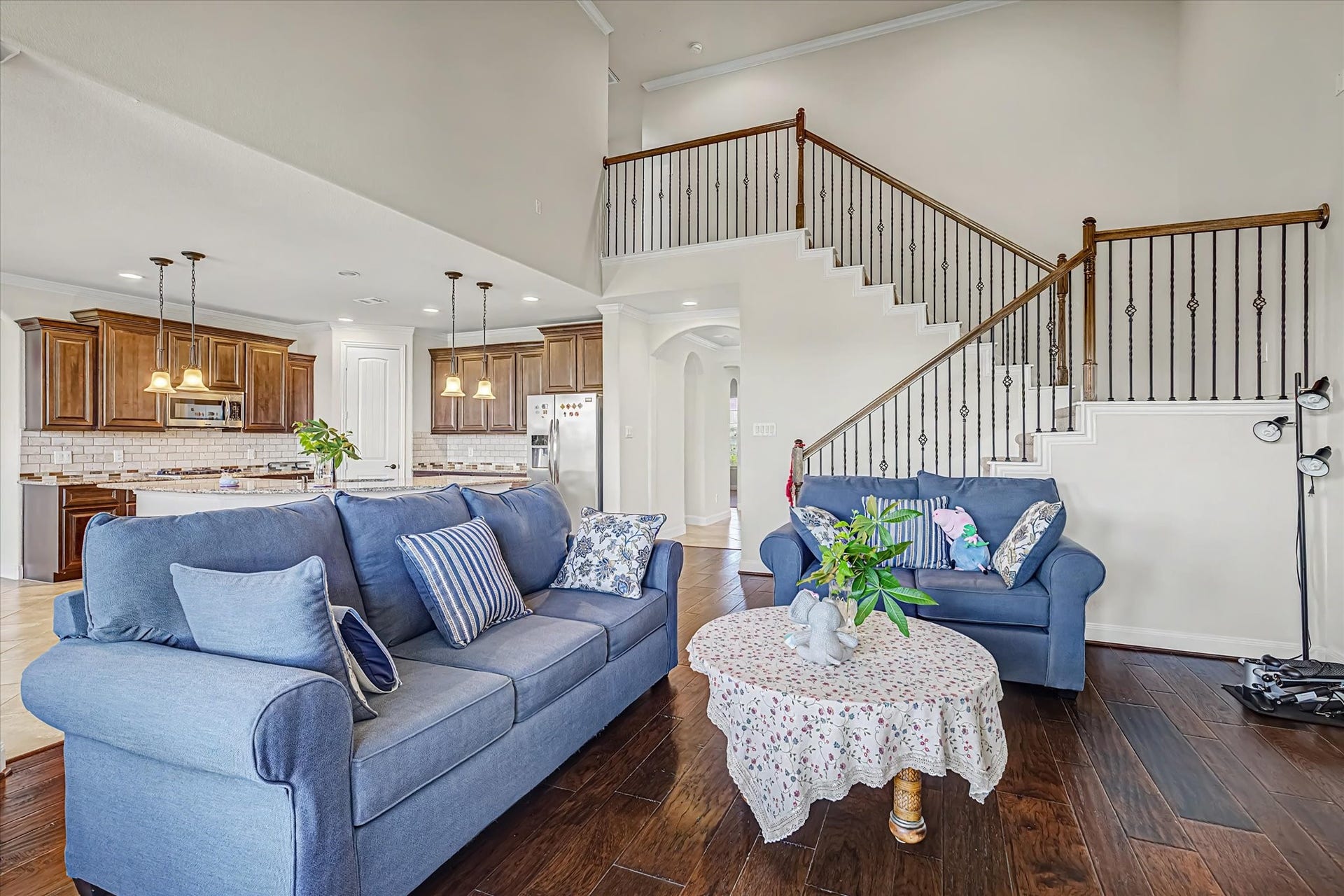 20302 Bandera Lake Lane, Richmond, TX 77407 Spacious living area with elegant wood flooring, and a charming staircase leading to the upper level. The open-concept design flows seamlessly into a modern kitchen with rich wood cabinetry and stainless steel appliances.