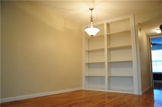 6001 Reims Road, #1202, Houston, TX 77036 This room features hardwood floors, a built-in bookshelf, and a chandelier, offering a cozy and functional space.