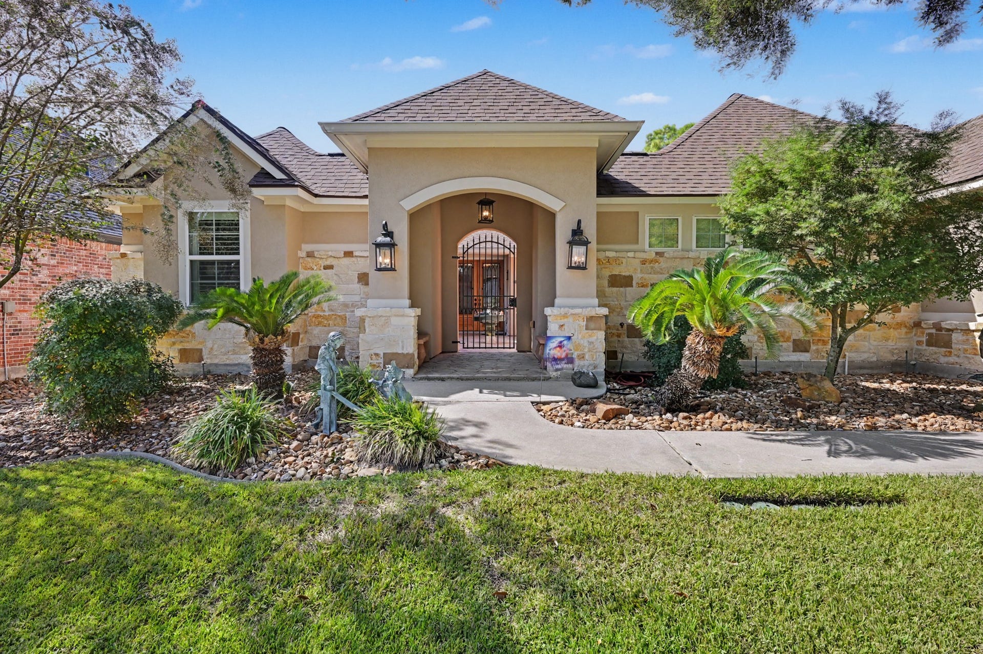 124 Wycliffe Drive, Montgomery, TX 77356 Elegant front elevation featuring a welcoming arched entry and beautiful stone accents.