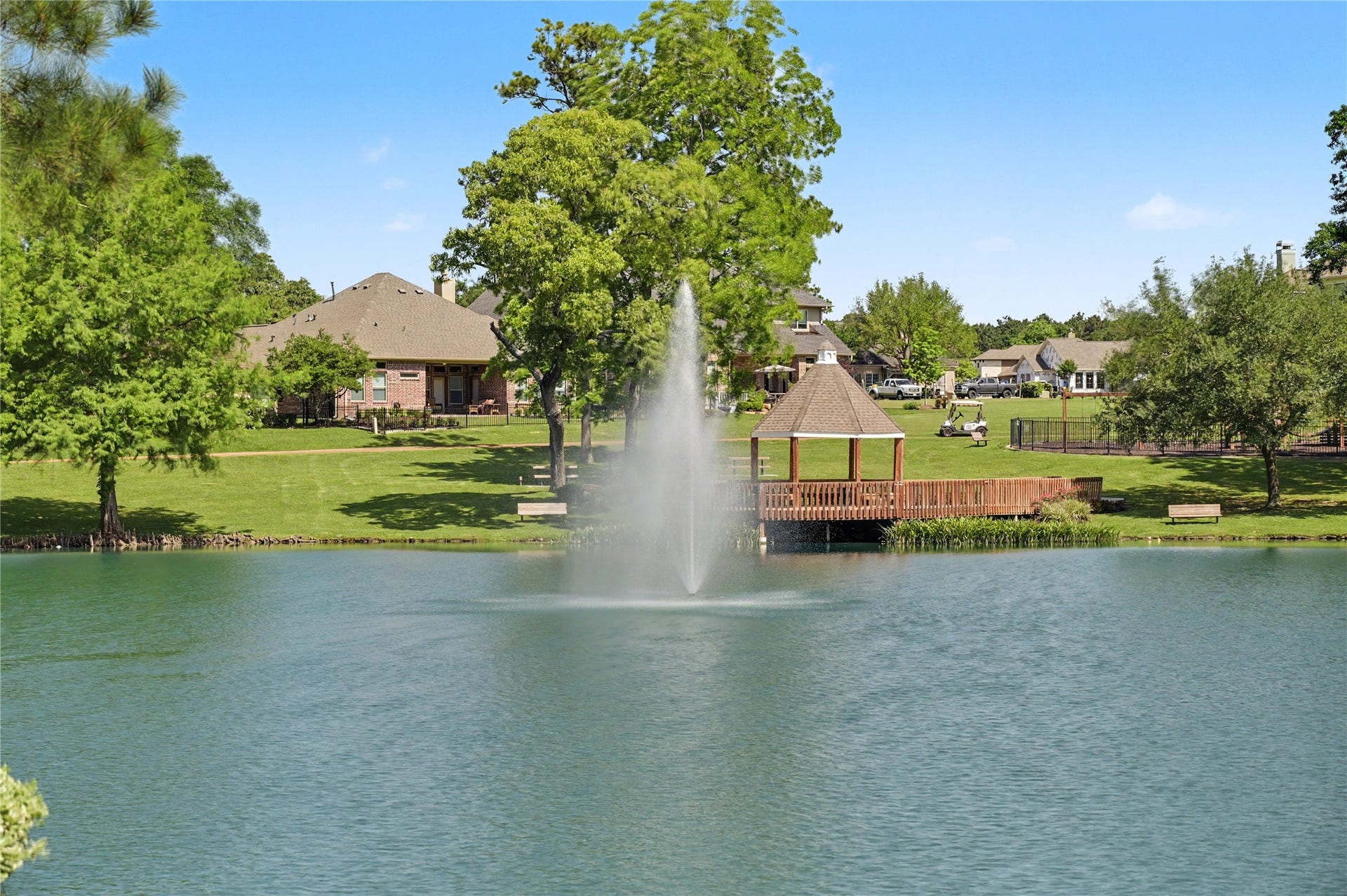124 Wycliffe Drive, Montgomery, TX 77356 Serene pond with a graceful fountain and lush surrounding landscape.