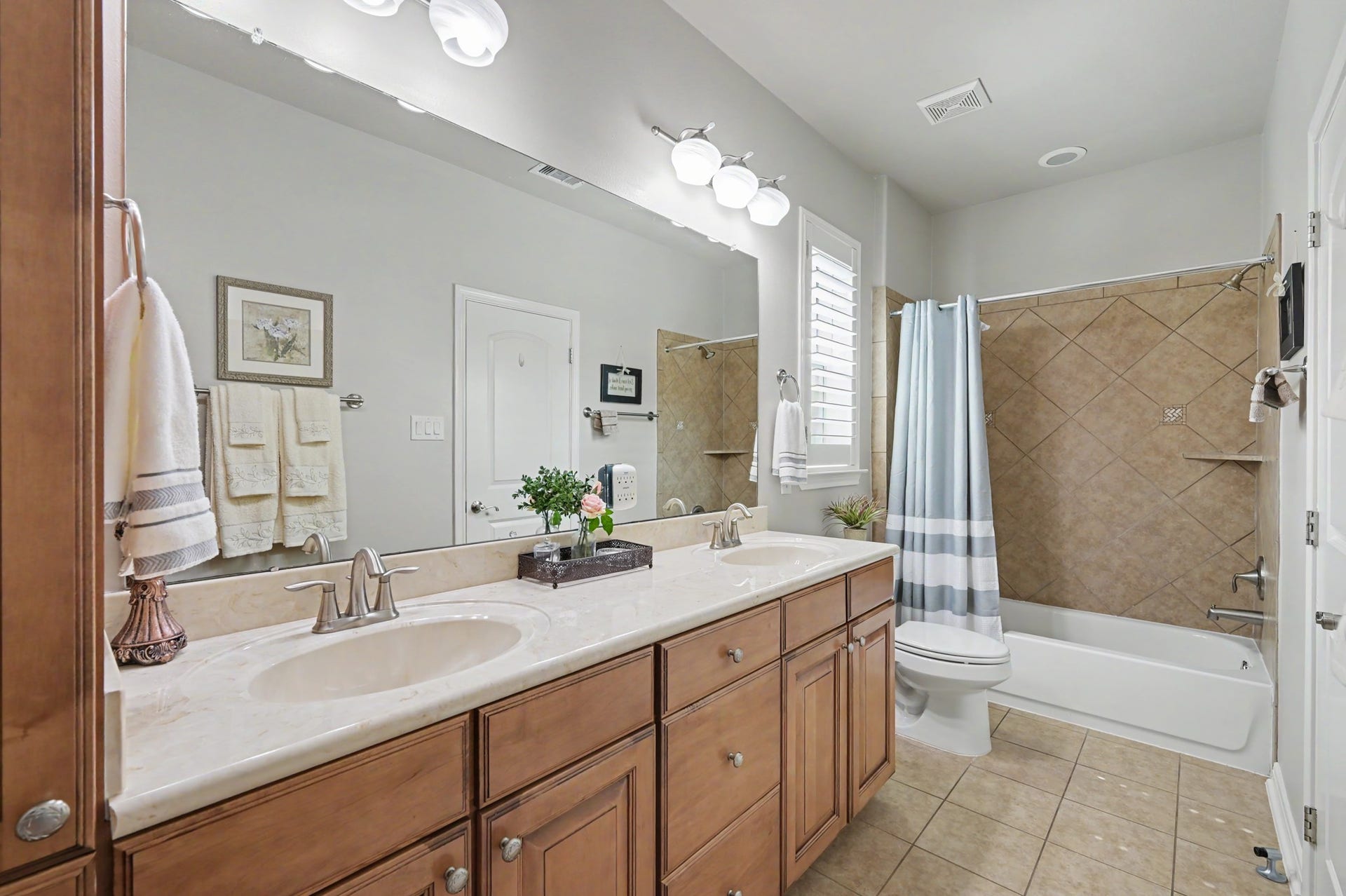 124 Wycliffe Drive, Montgomery, TX 77356 Beautifully appointed guest bathroom with dual sinks and tub-shower combination.