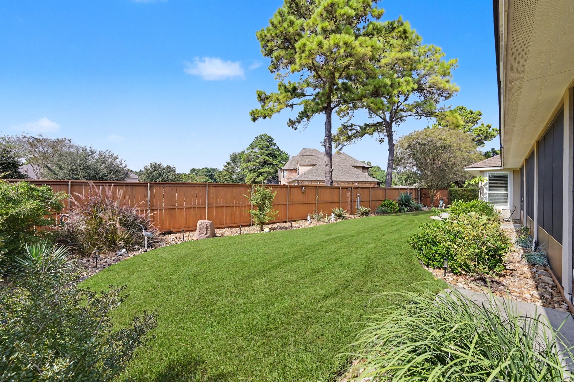 124 Wycliffe Drive, Montgomery, TX 77356 Beautifully maintained backyard with lush green lawn and attractive landscaping.
