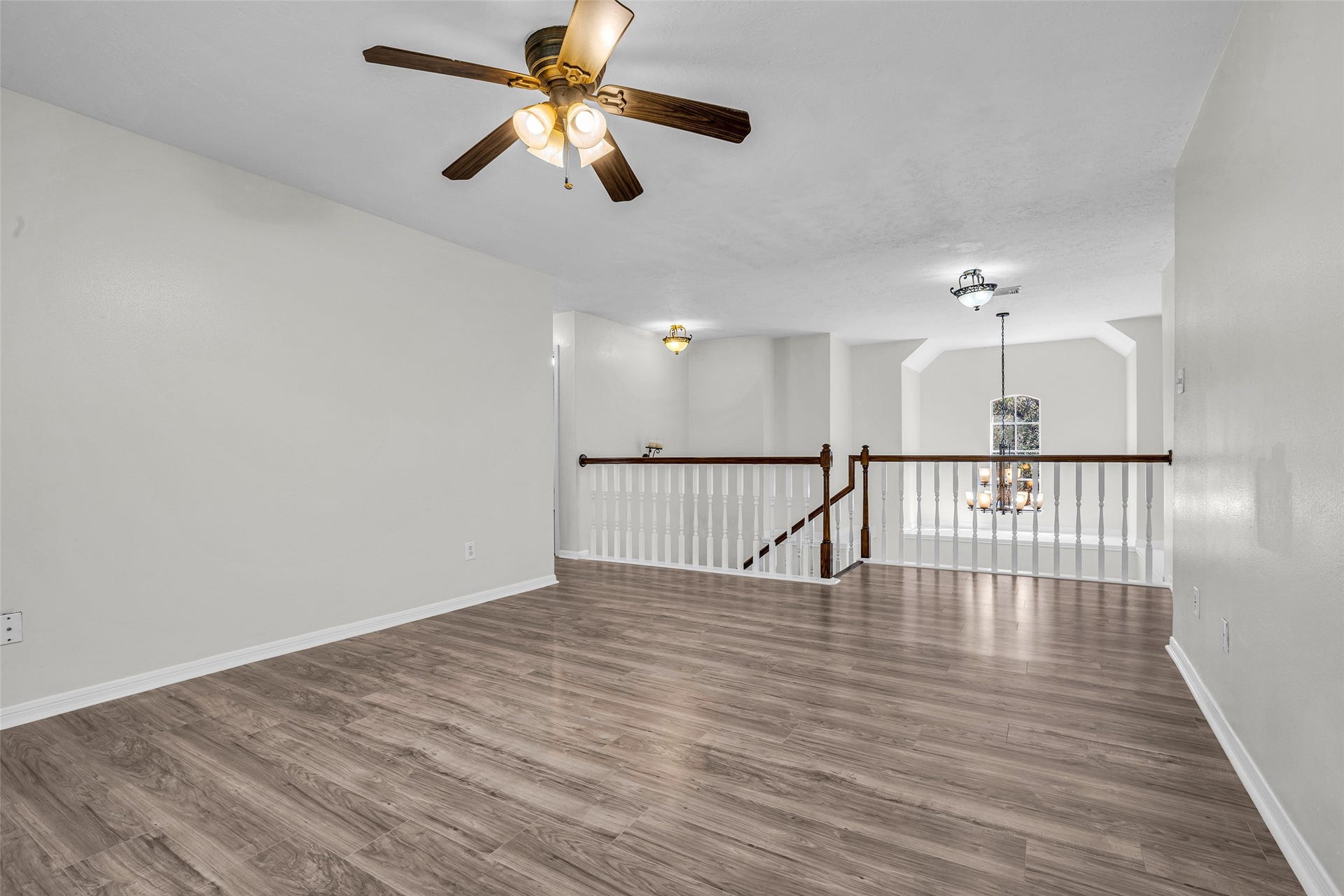 An upstairs game room with a view to the entry below, perfect for movie nights.