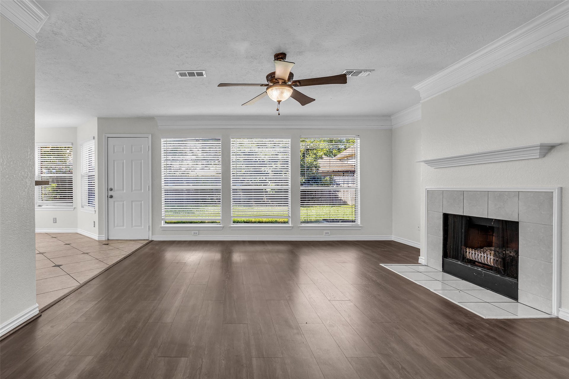 Plenty of natural light and room to spread out, with crown molding and a ceiling fan.