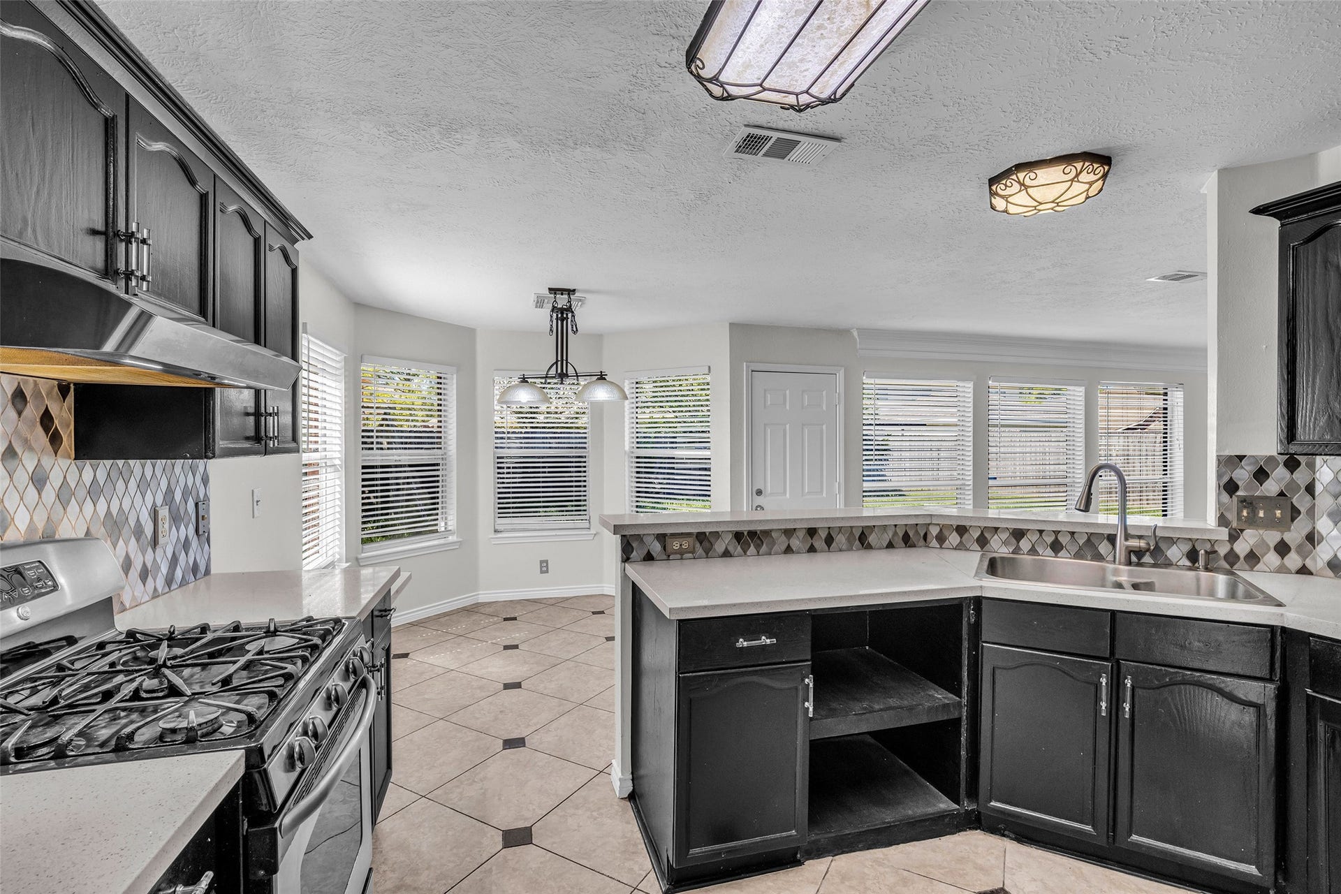 The kitchen opens to a bright breakfast area with bay windows.