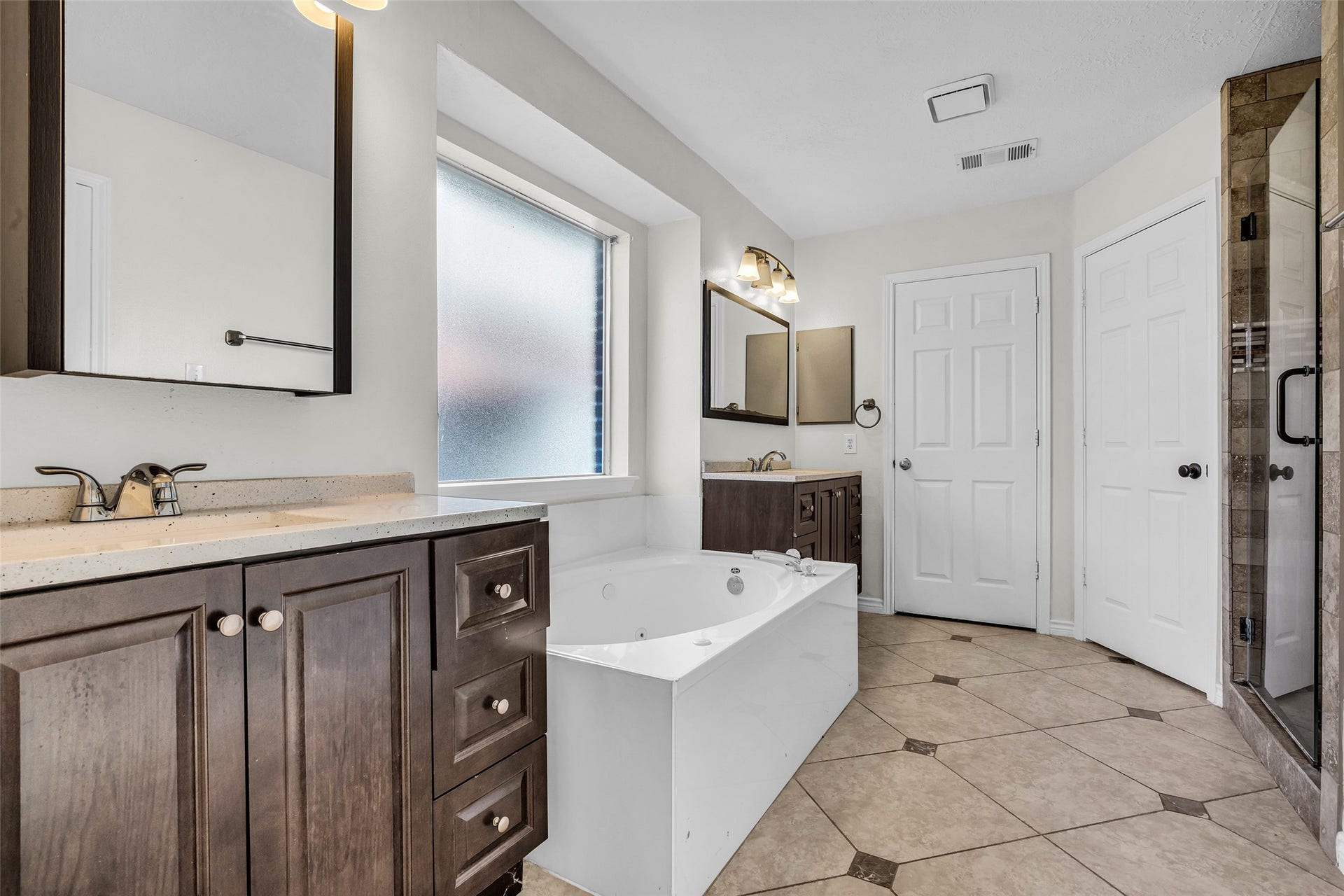 Relax in the jetted tub, with a large vanity and a window for natural light.