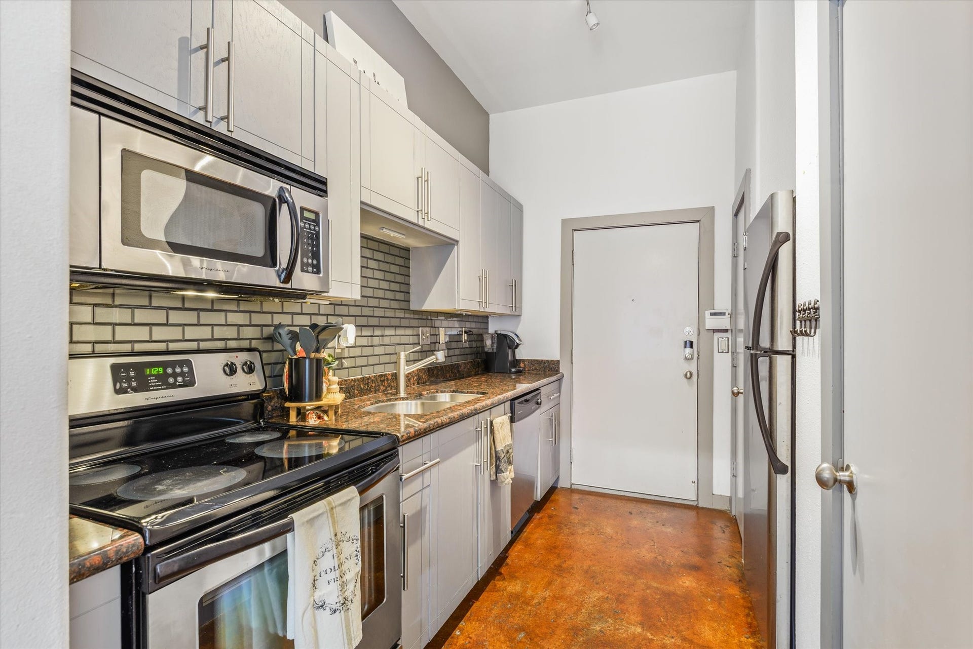 2205 Mckinney Street, #309, Houston, TX 77003 The stained concrete and the charm of the trim and paint colors make this kitchen inviting.