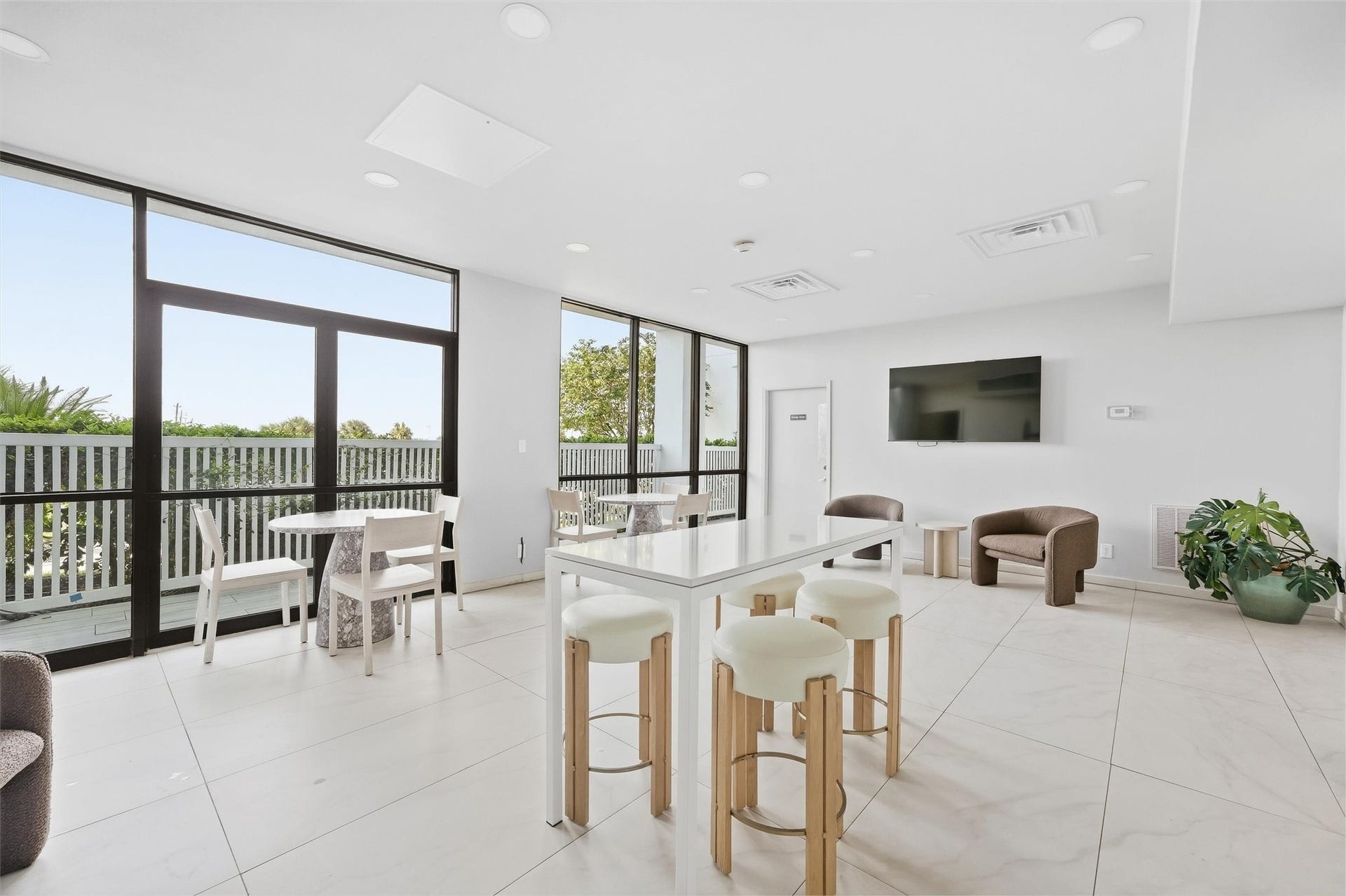 7310 Seawall Boulevard, #1105, Galveston, TX 77551 Bright and modern living area featuring large windows, sleek tile flooring, and a versatile open layout with a stylish table and comfortable seating, perfect for relaxation or entertaining.