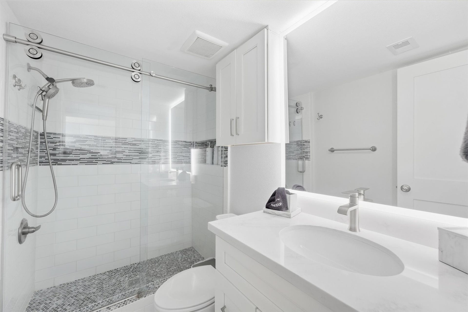 7310 Seawall Boulevard, #1105, Galveston, TX 77551 Stylish bathroom featuring a sleek glass-enclosed shower with modern tile accents, elegant fixtures, and a pristine white vanity for a refreshing, contemporary feel.