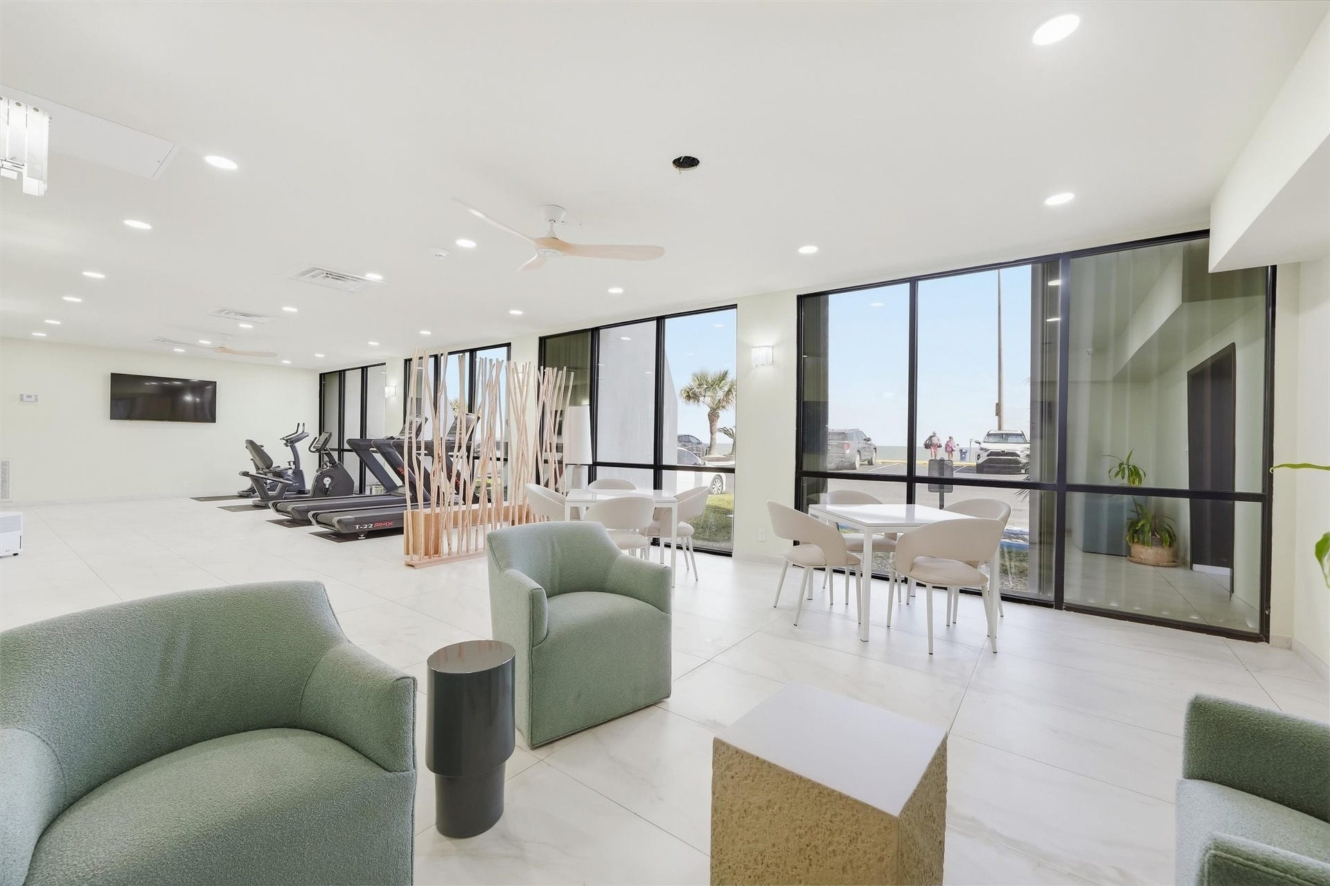 7310 Seawall Boulevard, #1105, Galveston, TX 77551 Bright and modern fitness and lounge area featuring large windows, comfortable seating, and exercise equipment, perfect for both relaxation and workouts.