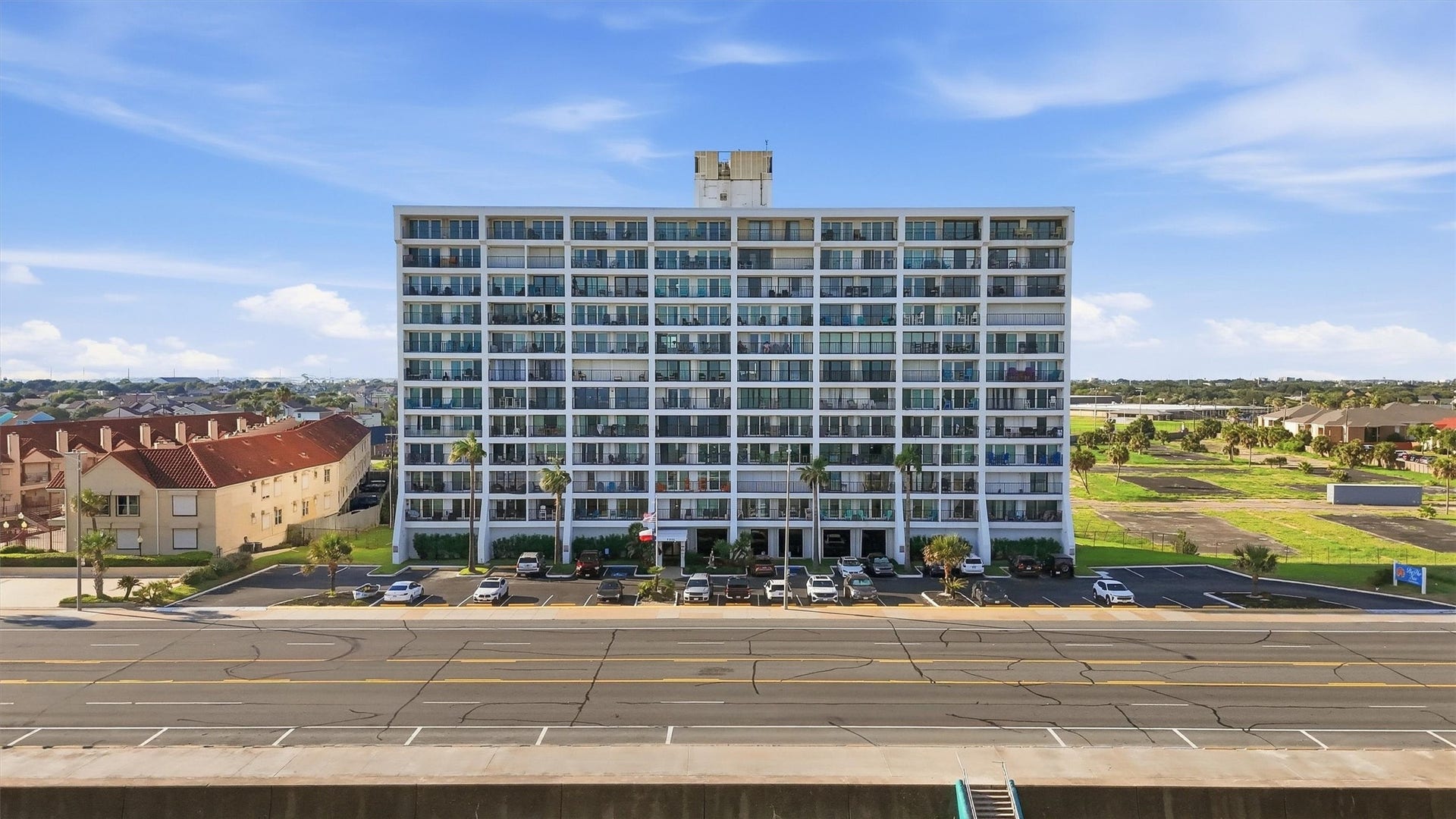 7310 Seawall Boulevard, #1105, Galveston, TX 77551 Modern high-rise building with ample parking, offering convenient urban living and expansive views.