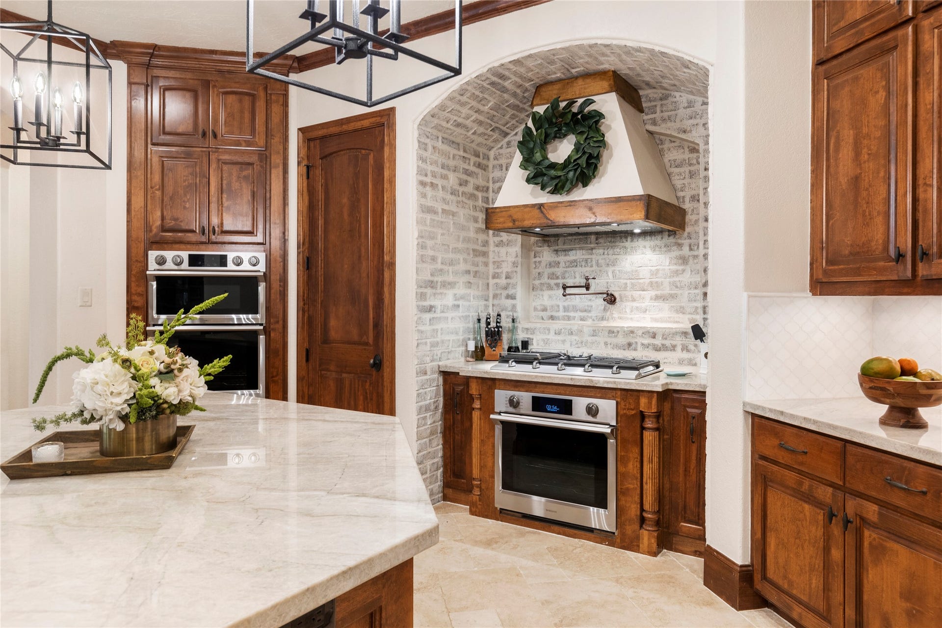 7421 Enchanted Stream Drive, Conroe, TX 77304 Note the unique and stylish German Smear brick accentuated by the custom hood vent + convenient pot filler.