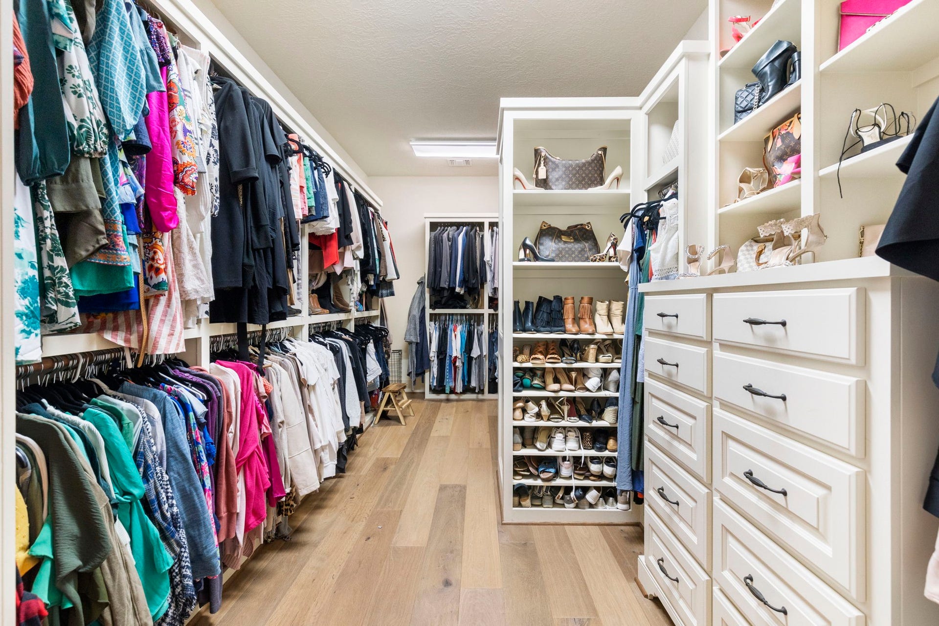 7421 Enchanted Stream Drive, Conroe, TX 77304 Massive walk-in primary closet with upgraded flooring and built-ins; perfect for keeping you organized! There is also a hidden closet at the back.