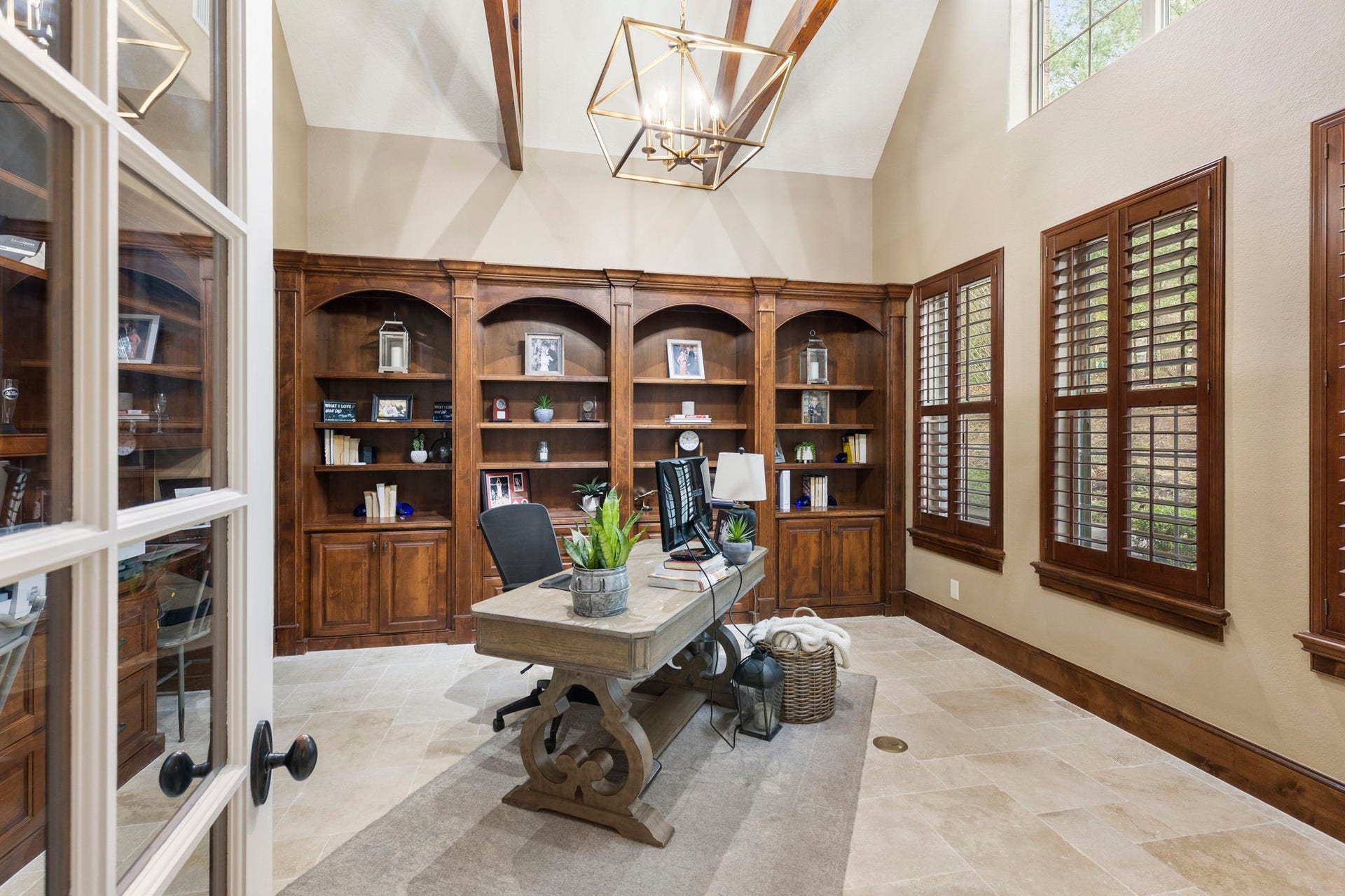 7421 Enchanted Stream Drive, Conroe, TX 77304 Sophistication meets style in this handsome study boasting two walls of custom built-ins, plantation shutters, travertine floors and high, beamed ceiling.