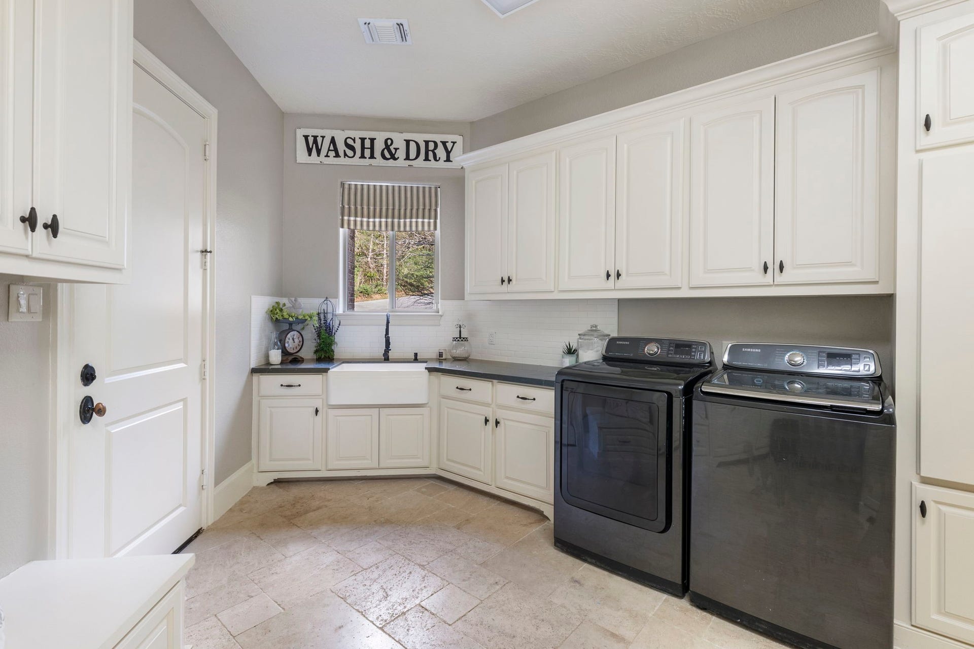 7421 Enchanted Stream Drive, Conroe, TX 77304 Mudroom + utility room + storage room and more! Don't miss the farmhouse sink and subway tile backsplash (and, of course, additional nature views)!