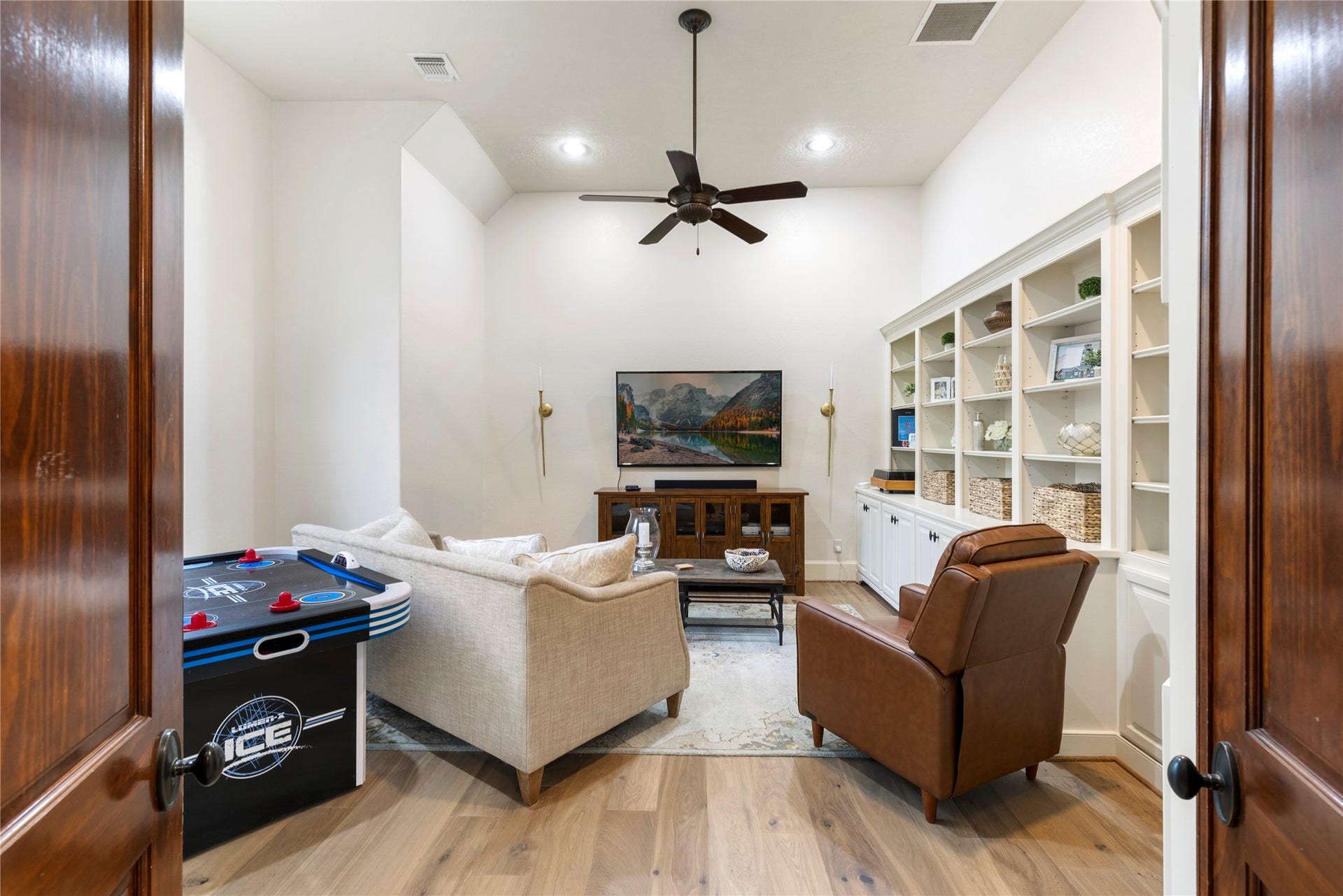 7421 Enchanted Stream Drive, Conroe, TX 77304 This 5,000+ sq.ft. home features this huge gameroom with a wall of built-ins, high ceilings + ceiling fan, 6in oak wood floors. This could also be used as a 6th bedroom.
