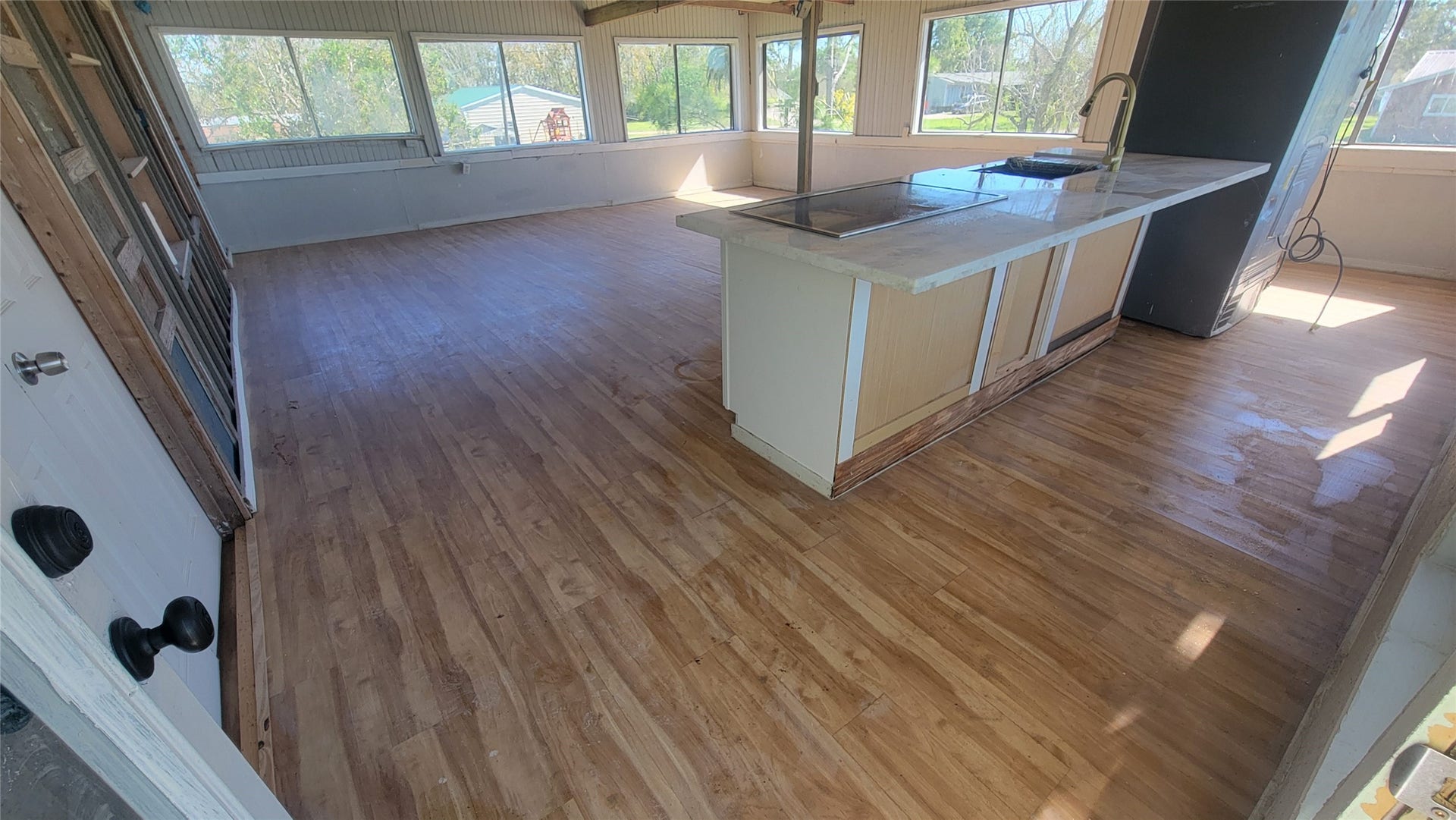 12018 Sandpiper Road, Angleton, TX 77515 Bright, spacious kitchen with large windows, light wood flooring, and a central island with a sleek countertop, perfect for cooking and entertaining.