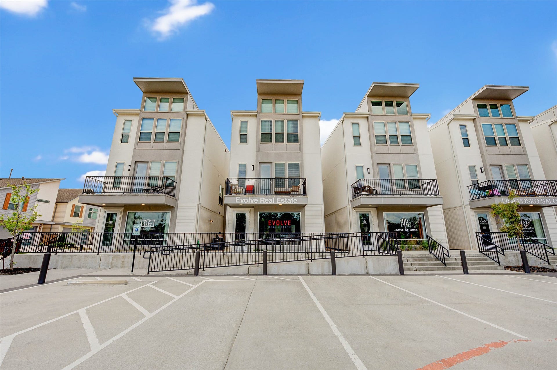 18732 Centro Main Street, Shenandoah, TX 77385 Modern townhouses with three stories, featuring large windows and balconies. The complex has a clean, contemporary design with a spacious parking area in front. Ideal for urban living.