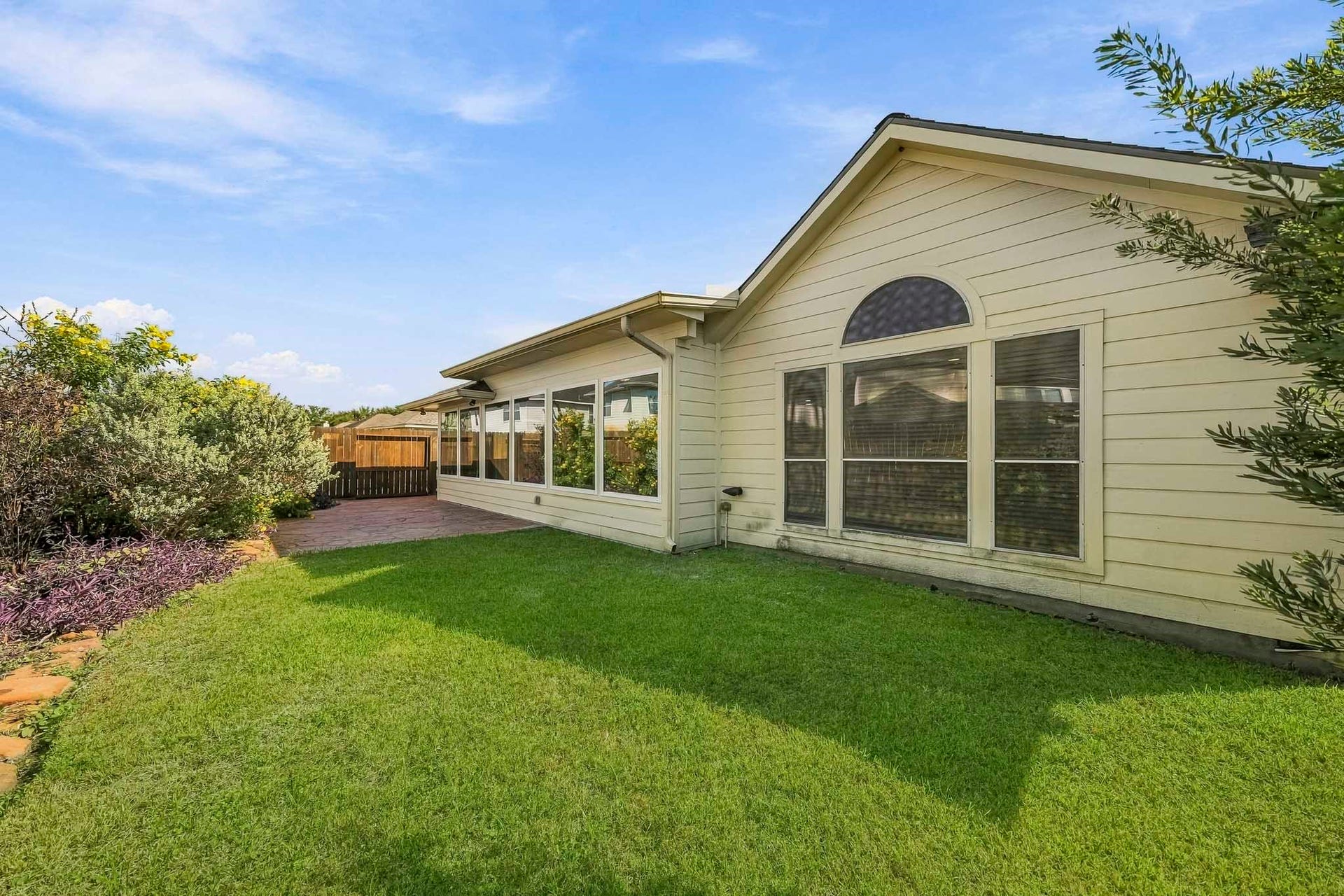Beyond the patio, you will find expansive, open yard space that provides endless possibilities for your outdoor enjoyment, whether you are hosting weekend summer gatherings, setting up a play area, or simply relaxing in your own private, green oasis. This outdoor area is designed for both peaceful relaxation and vibrant entertaining, seamlessly blending natural beauty with functional space for your lifestyle needs.