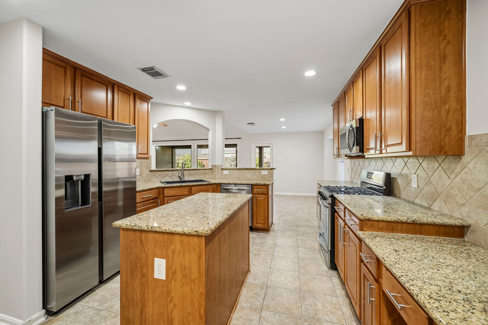 Spacious kitchen island provides ample surface area for meal preparation, baking, or versatile home projects.