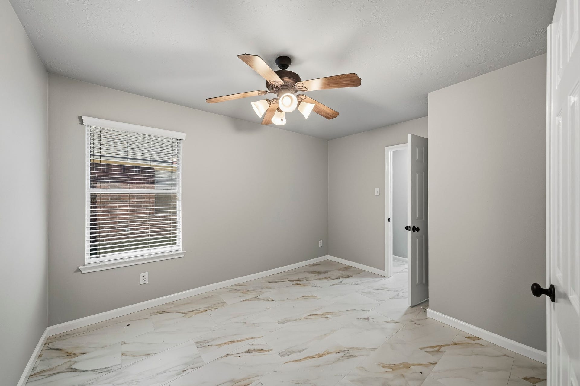 Private home office featuring sleek tile flooring and elegant double doors for added privacy. The room includes a ceiling fan for year-round comfort and offers a convenient layout that connects directly to the primary bedroom suite.